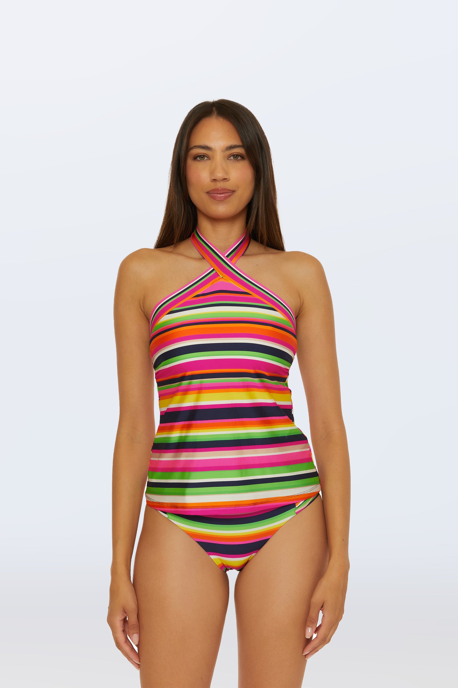 A woman with long brown hair models the Reversible Tankini Swim Top - Splash Stripe in Multi, paired with matching bikini bottoms, standing against a plain white background.