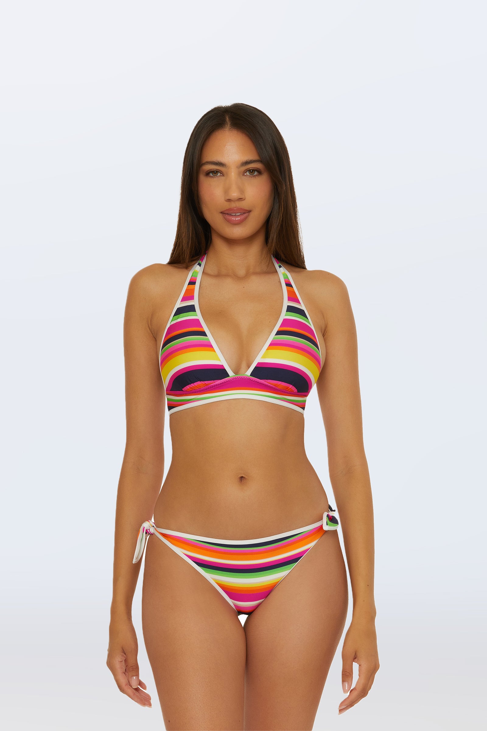 A woman faces forward in the Reversible Halter Swim Top - Splash Stripe, featuring a multi-color striped design and paired with coordinating side-tie bottoms, set against a plain light background.