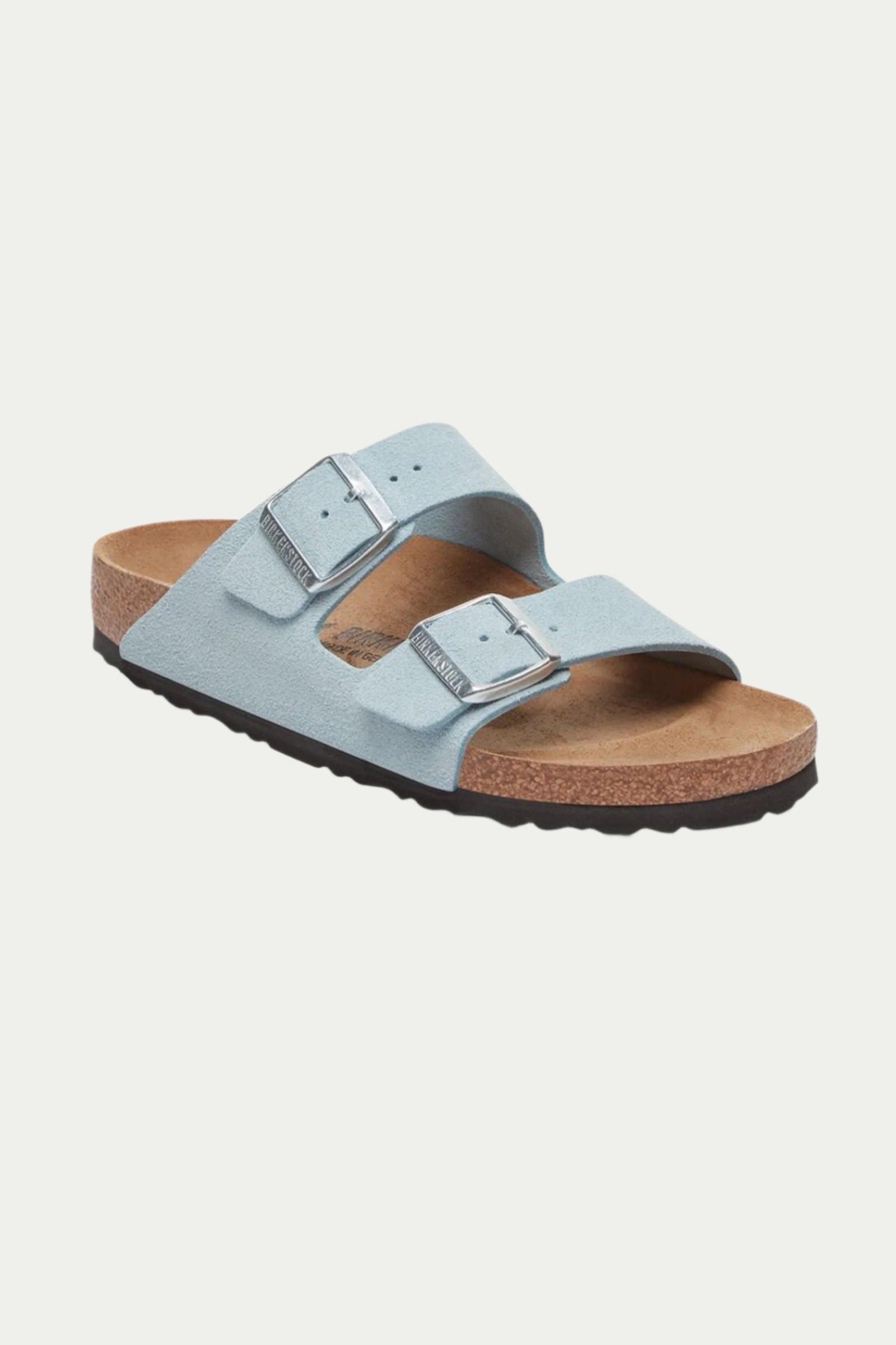 The Womens Arizona Suede Sandal in Baby Blue features two wide straps with silver buckles, a cork footbed, and a black textured sole, displayed angled on a white background.