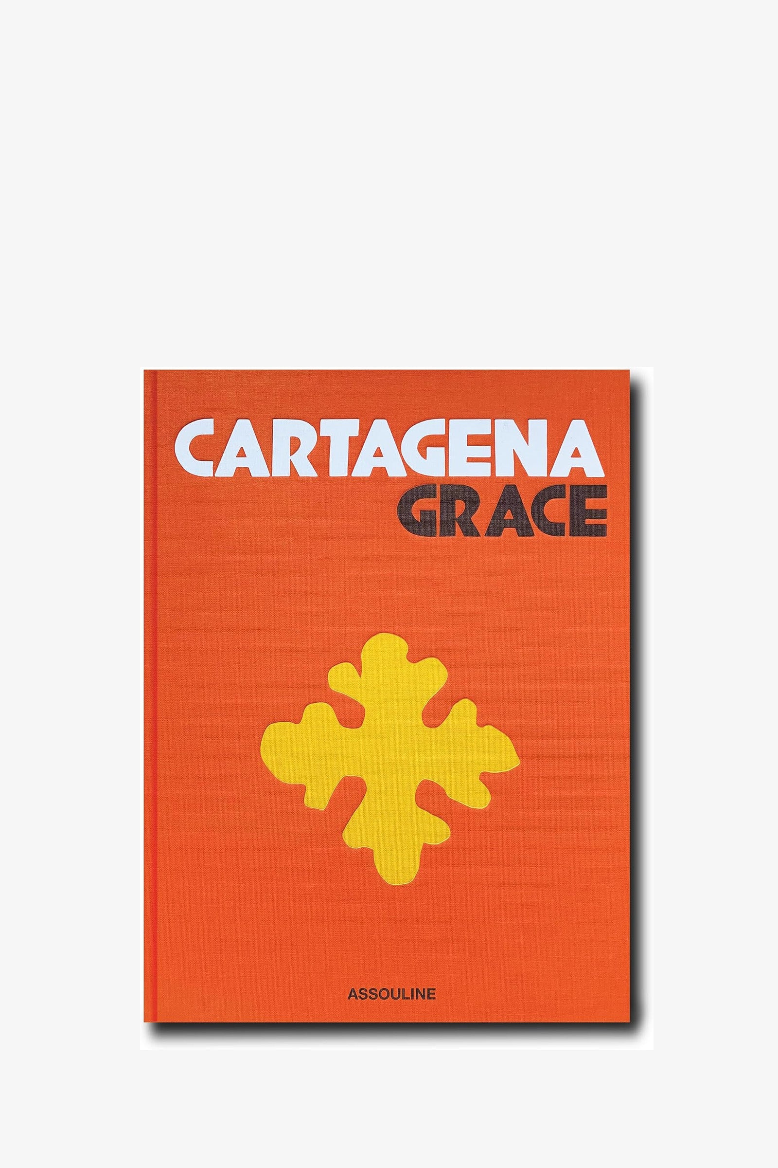 An orange Assouline Cartagena Grace Book featuring a large yellow abstract shape on the cover and “ASSOULINE” printed at the bottom.