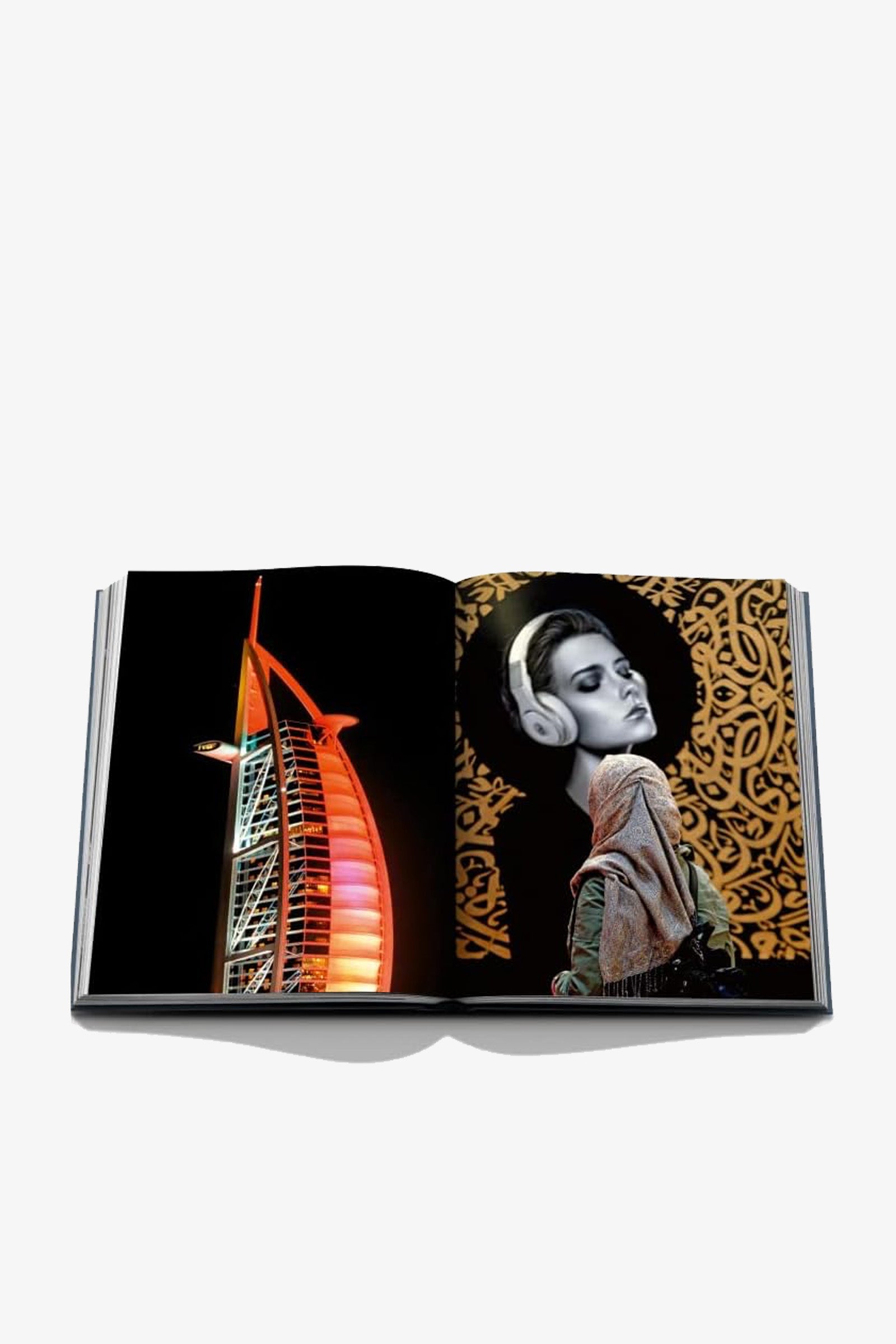 An open copy of Assouline Dubai Wonder displays a photo of the Burj Al Arab illuminated at night on the left page and a woman wearing headphones against an ornate gold background on the right page.