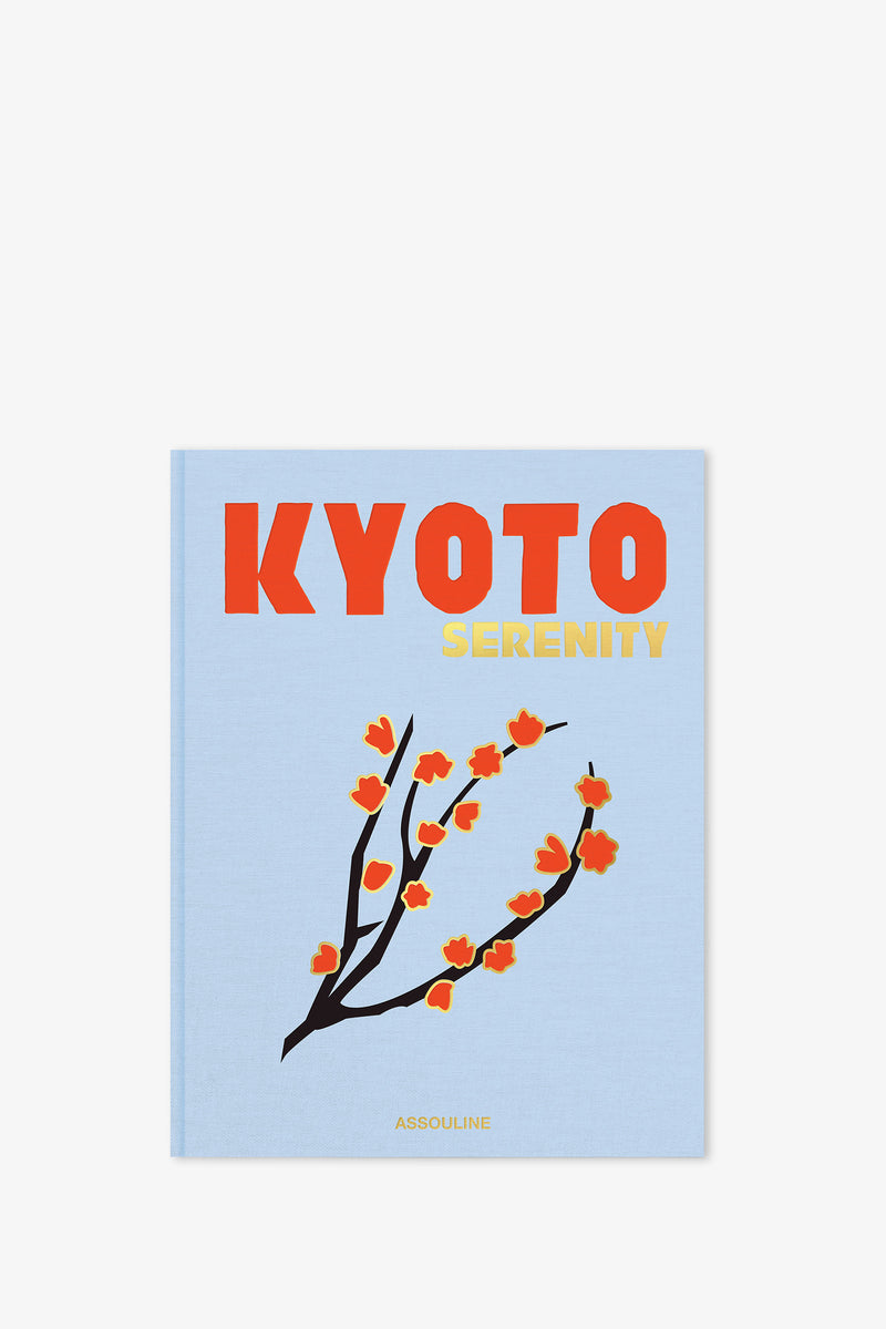 A light blue Assouline Kyoto Serenity Book featuring bold orange and yellow lettering on the cover, adorned with an illustration of a branch with red-orange flowers. The publisher "Assouline" appears at the bottom.