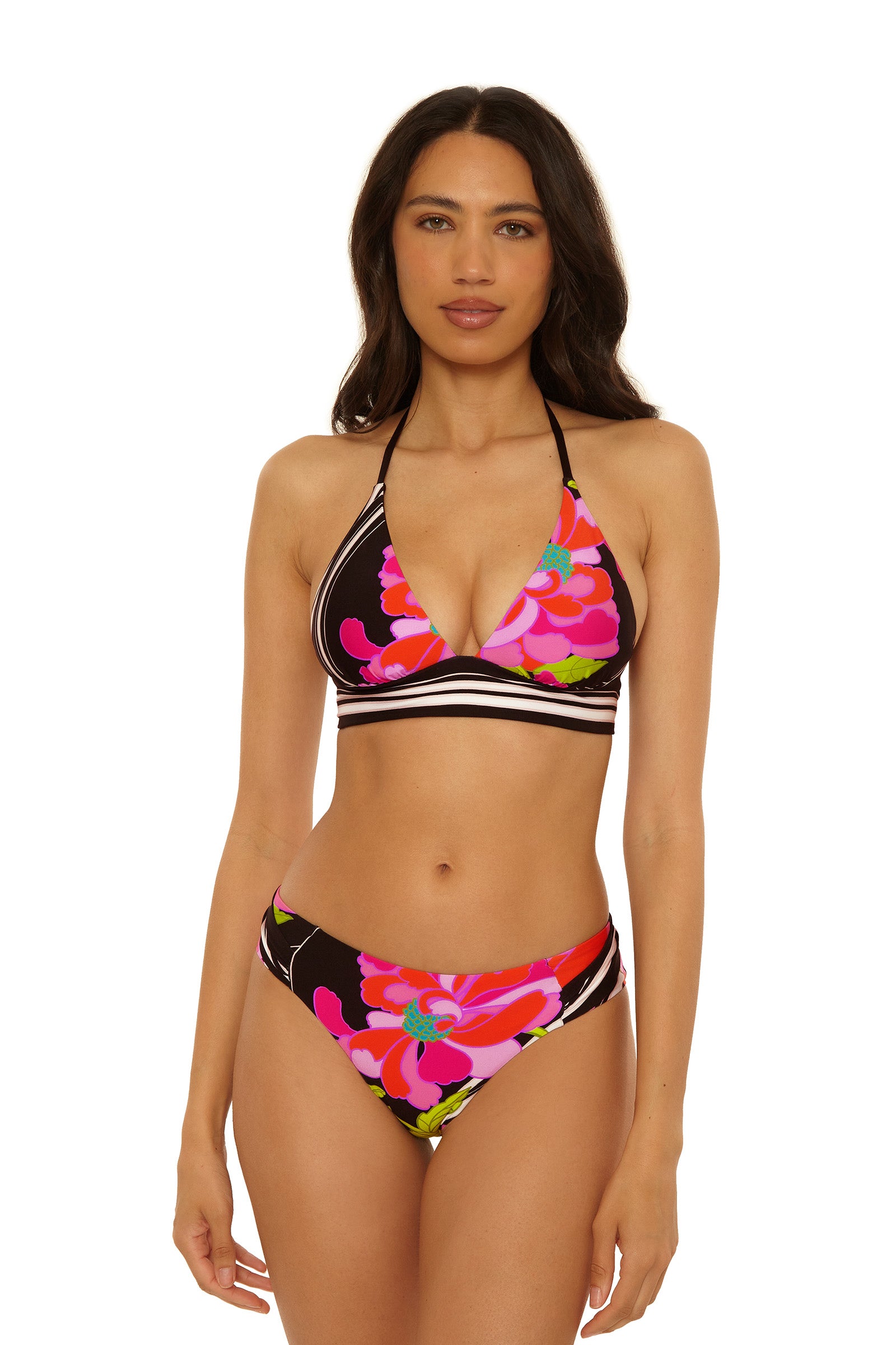 A woman models the Tab Side Hipster Swim Bottom - Bougainvillea, featuring a black base with pink and red floral print and striped accents, against a plain white background.