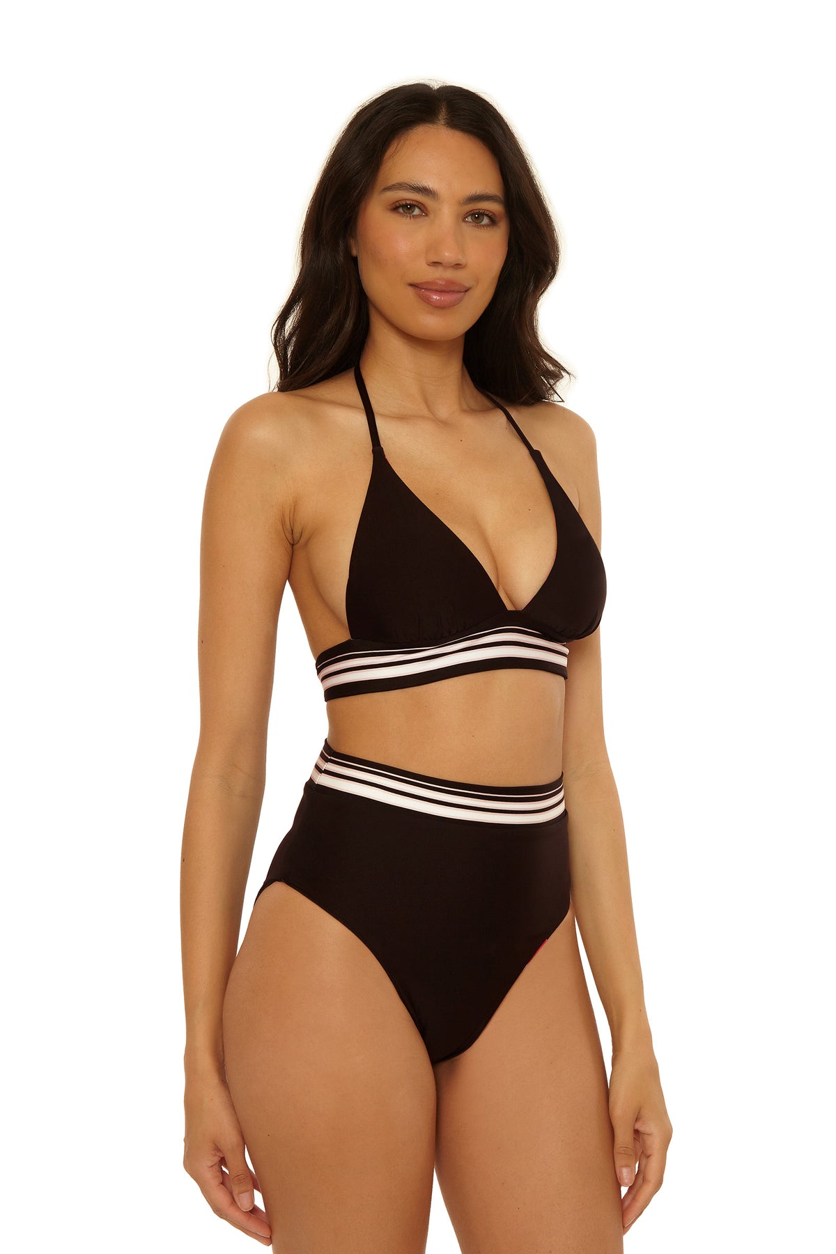 A woman with long dark hair models the High-Waist Swim Bottom - Bougainvillea, a black high-waisted bikini bottom with white and pink striped bands, paired with a matching halter top, against a plain white background.