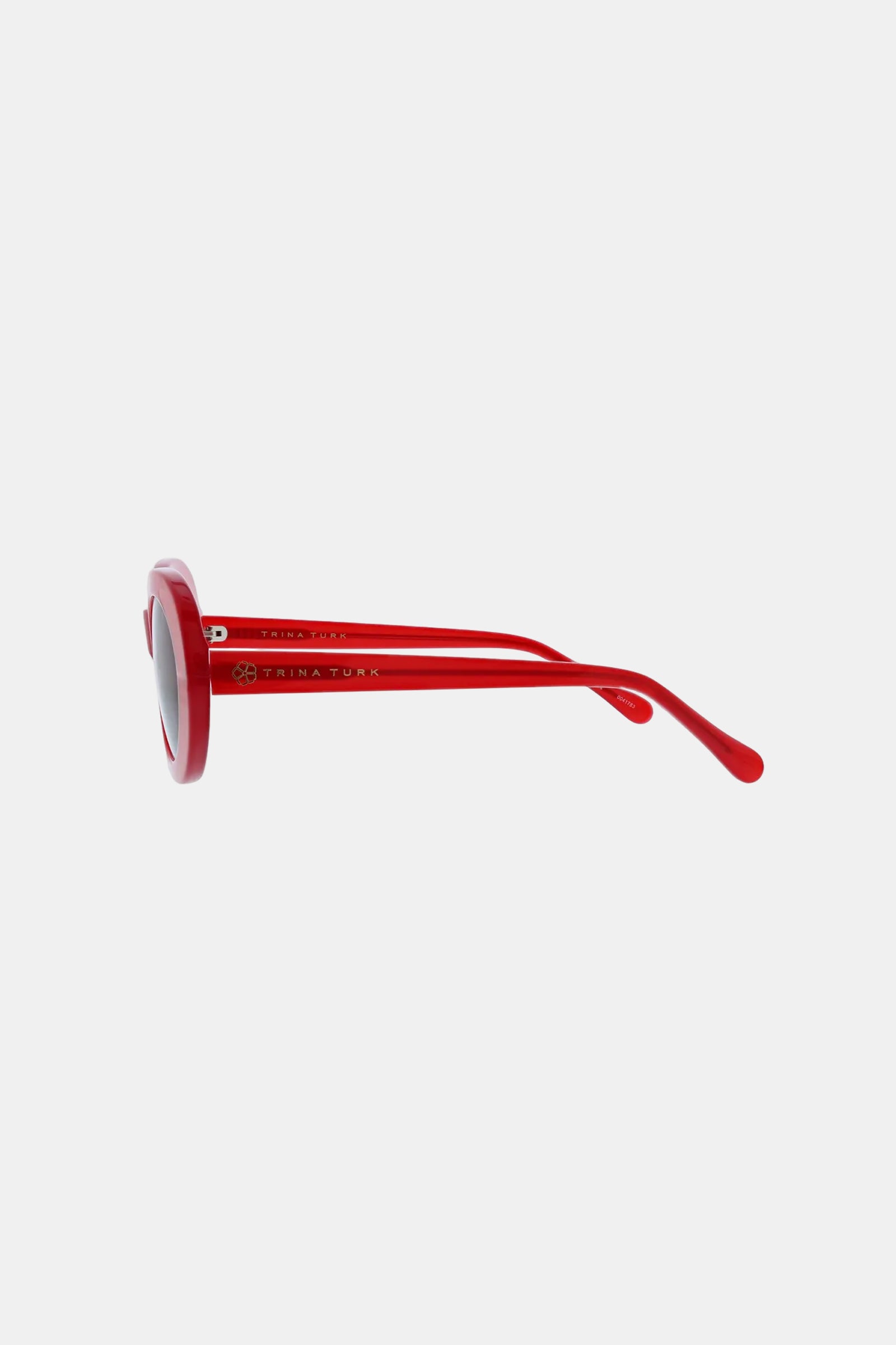 Side view of the Carova Sunglass featuring red frames, round lenses, and gently curved arms, displayed against a plain white background.