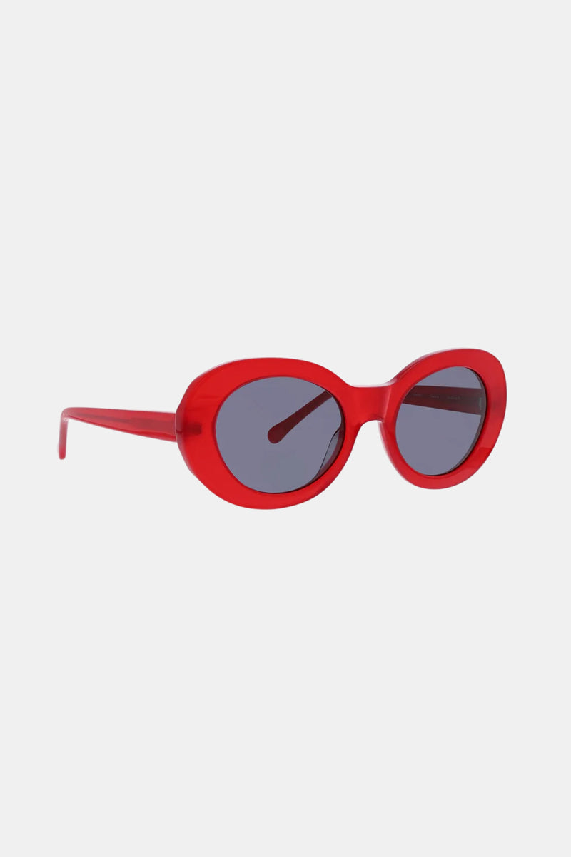 Carova Sunglass: Red oval-shaped sunglasses featuring thick plastic frames and dark tinted lenses, shown against a plain white background.
