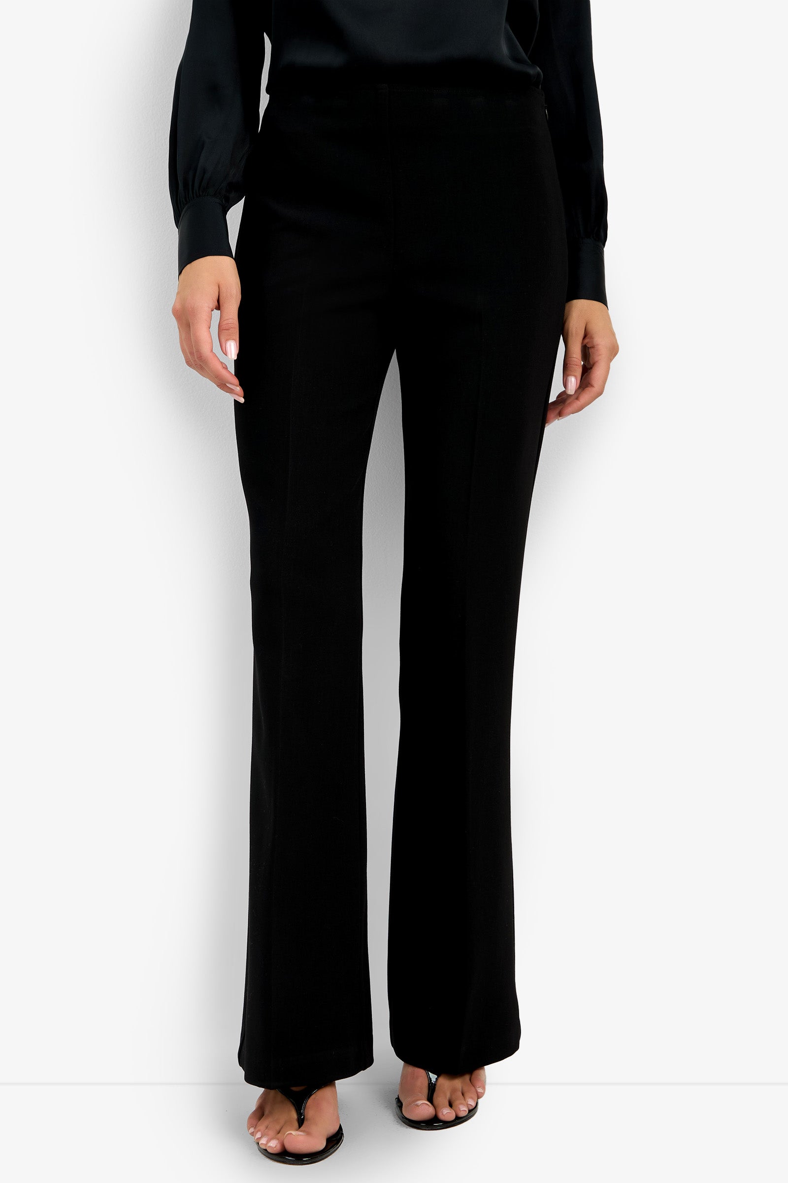 A person wearing the Chimayo Pant and a black long-sleeve blouse stands against a white background, shown from shoulders down, with open-toe black heels visible.