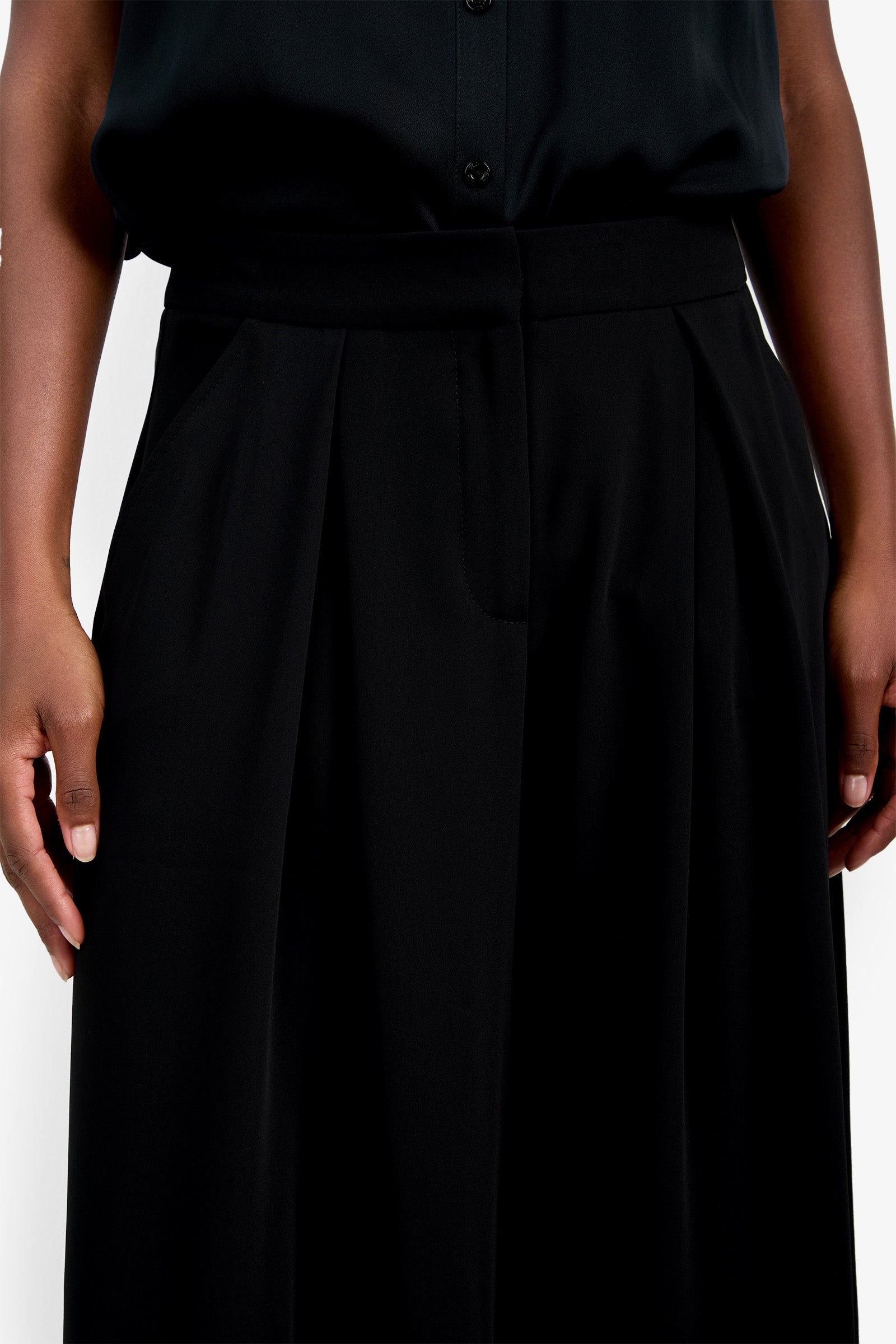 A person wearing the Saige Long Pant, shown from waist to mid-thigh, with hands resting at their sides.