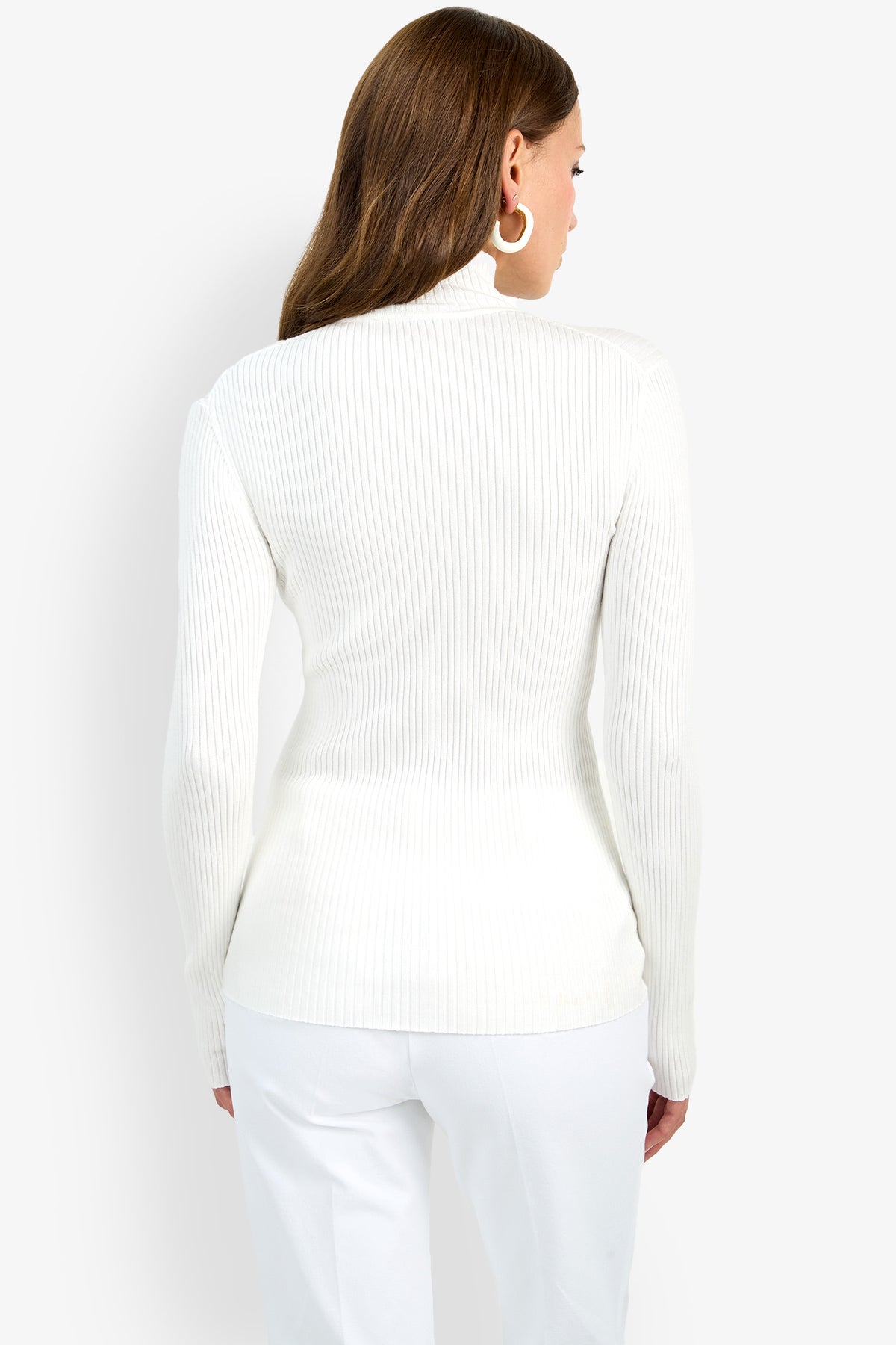 A woman with long brown hair models the Hempstead Mock Neck Top in white, paired with matching pants. She stands with her back to the camera against a plain light background.