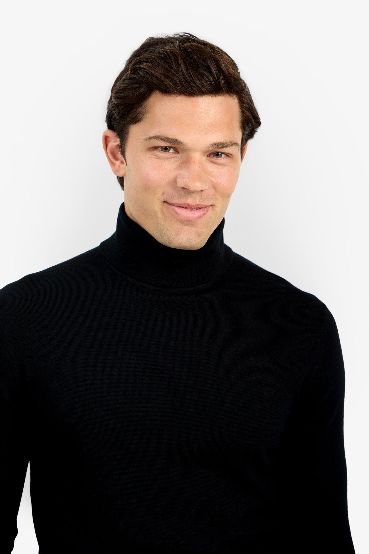 A man with short brown hair, dressed in the Roy Long Sleeve Turtleneck, smiles slightly while standing against a plain white background.