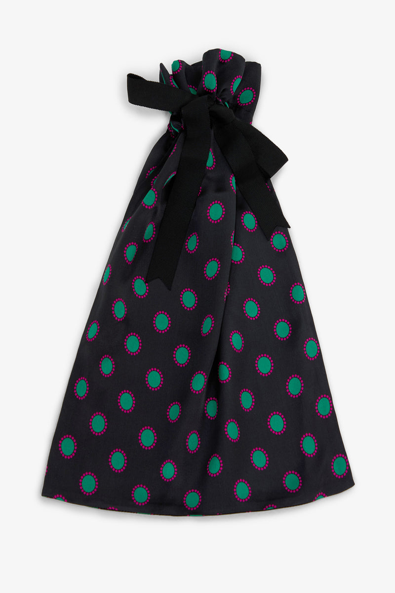 GEMSTONE PAJAMA GIFT BAG in black featuring a repeating pattern of green circles outlined in pink, tied at the top with a black ribbon.
