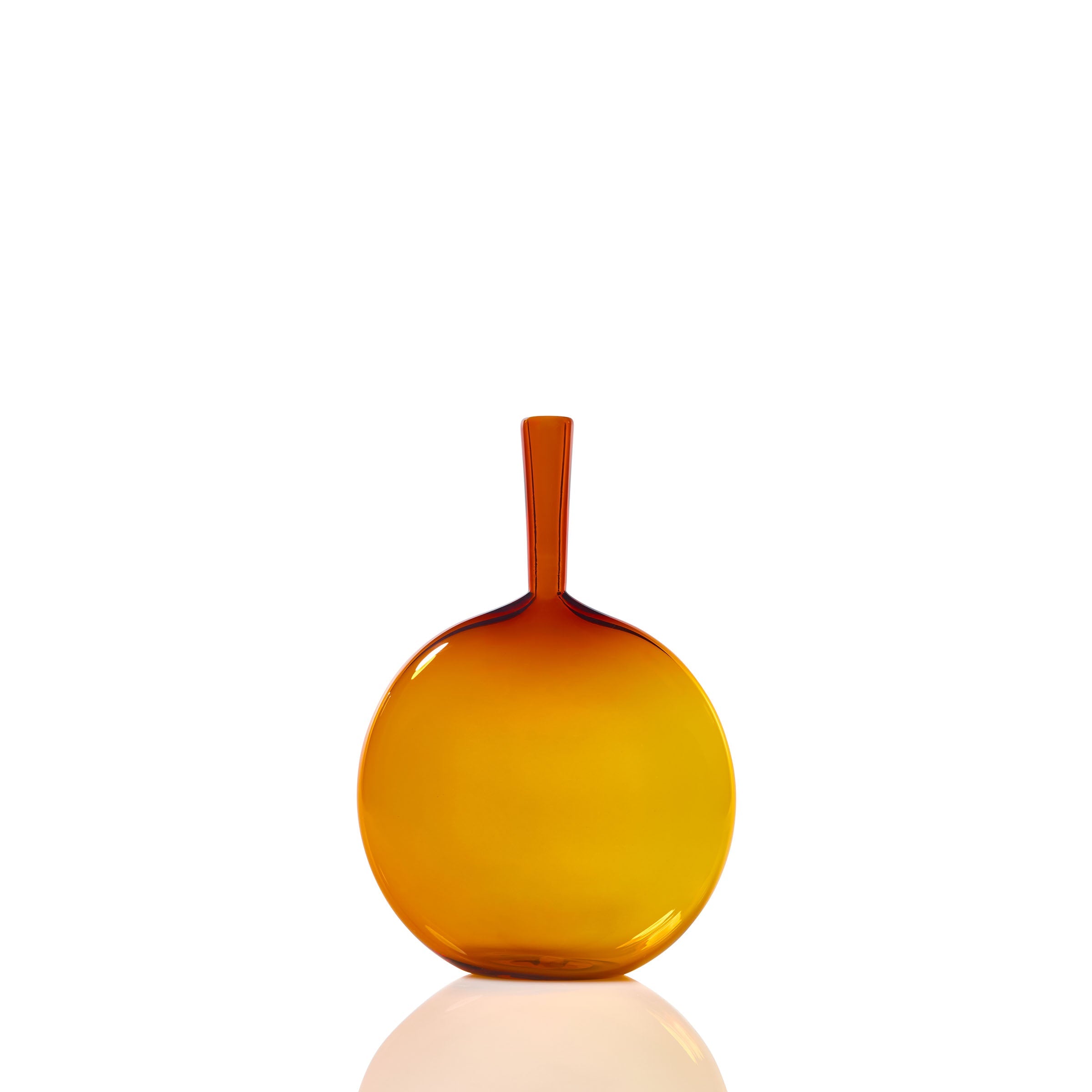 The Flask Angelic Bottle features a round, flat design in amber glass with a narrow neck and smooth finish, highlighting handcrafted blown glass artistry against a white backdrop with a subtle base reflection.