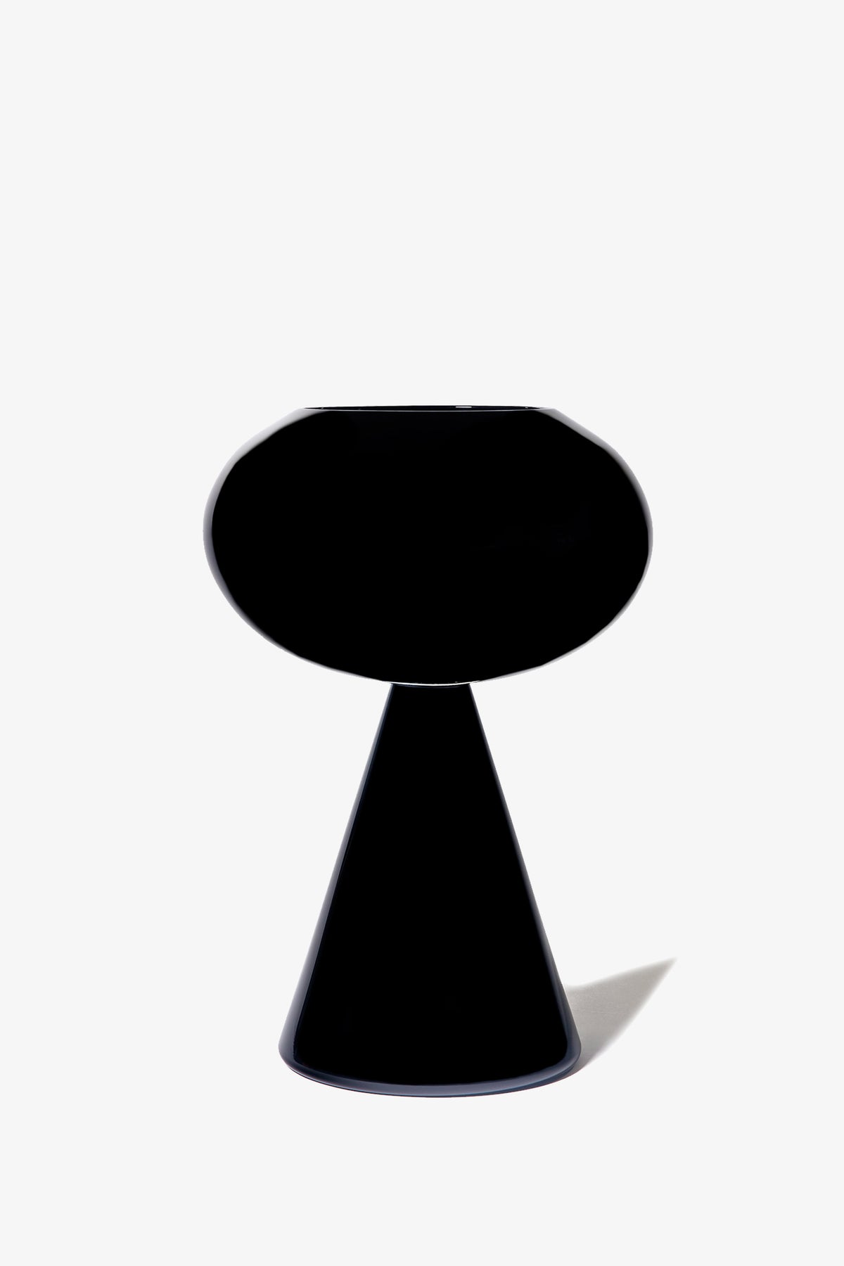 The Fiorelli Concave is a modern black table lamp featuring an oval shade and a conical base, displayed against a plain white background.