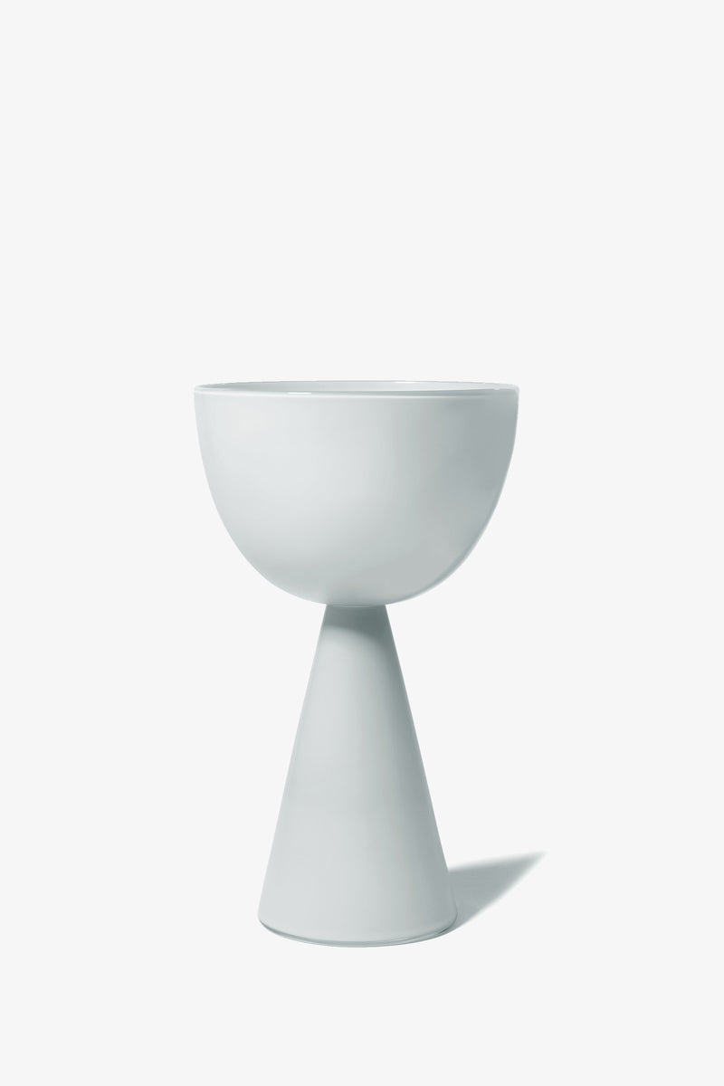 The Fiorelli Low Bowl is a modern white ceramic planter featuring a round bowl atop a conical base, displayed against a plain white background.
