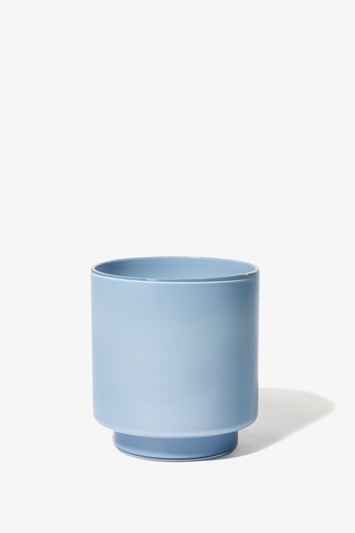 The Fiorelli Low Container, a light blue cylindrical ceramic pot with a slightly wider base, is shown on a white background with a soft shadow to the right.