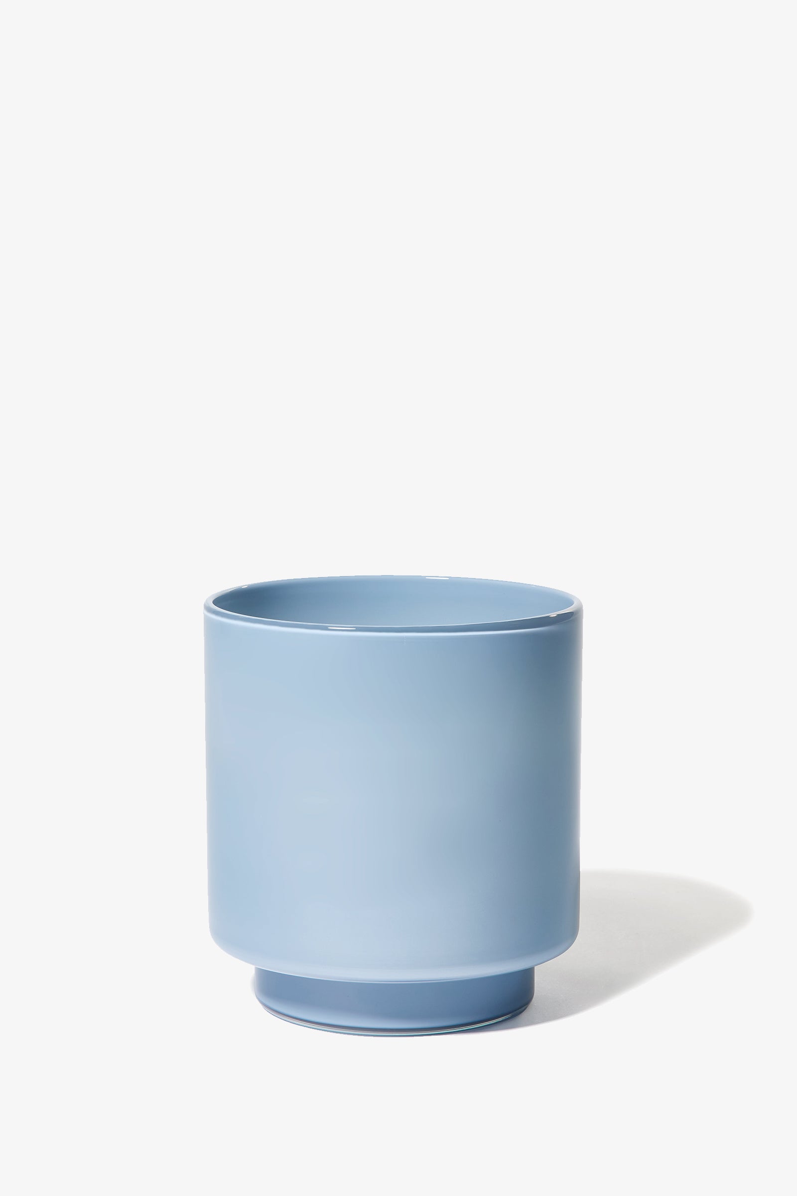 The Fiorelli Low Container, a light blue cylindrical ceramic pot with a slightly wider base, is shown on a white background with a soft shadow to the right.
