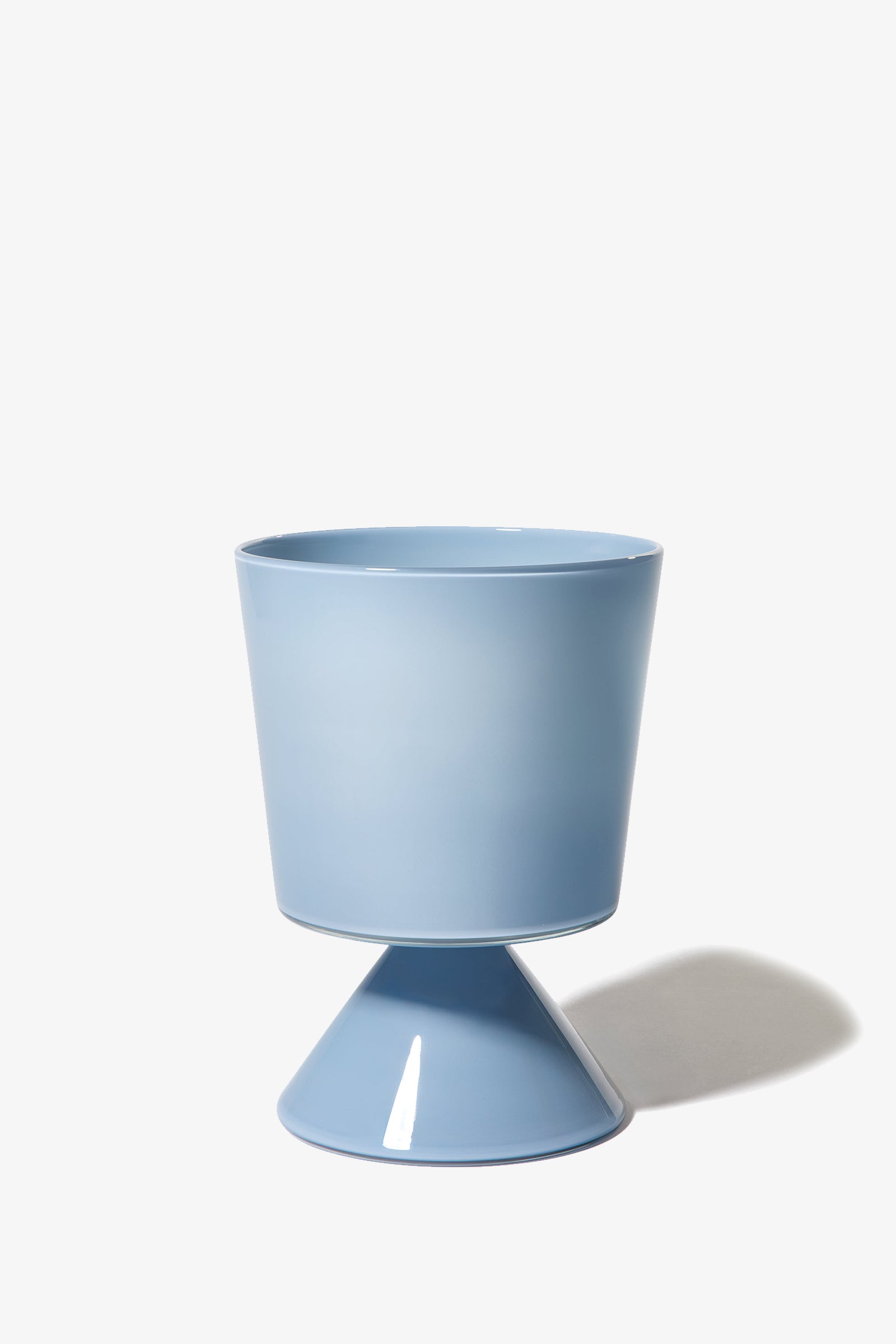 The Fiorelli Low Taper planter, featuring a modern blue design with a cylindrical top and cone-shaped base, is displayed against a white background with a subtle shadow on the right.