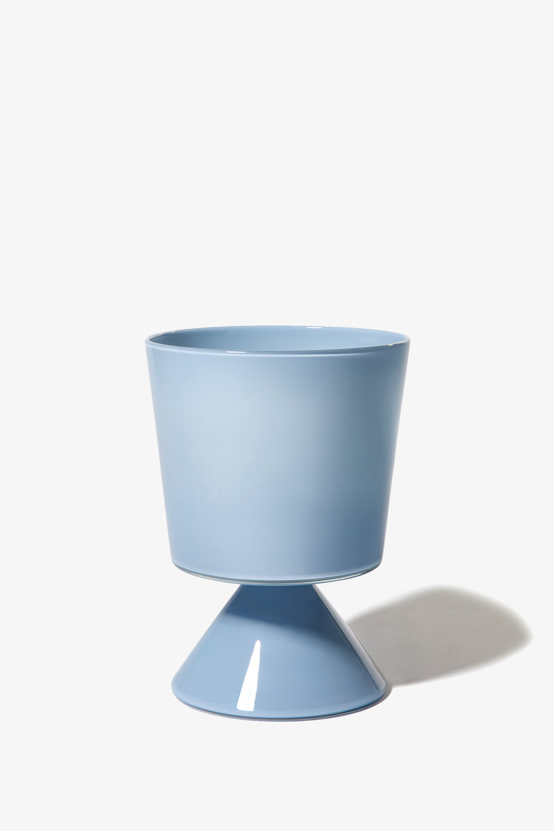 The Fiorelli Low Taper planter, featuring a modern blue design with a cylindrical top and cone-shaped base, is displayed against a white background with a subtle shadow on the right.