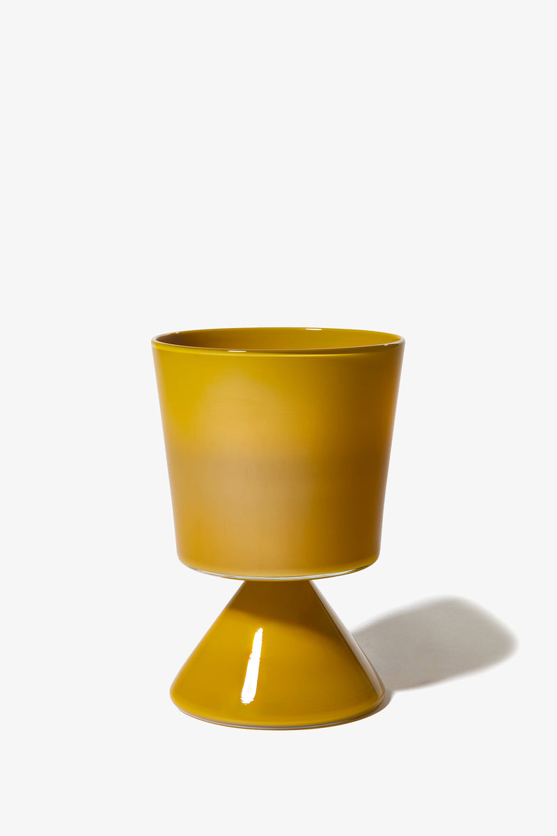 A modern ceramic planter, the Fiorelli Low Taper, in mustard yellow with a wide top and a cone-shaped base, casting a shadow on a white background.