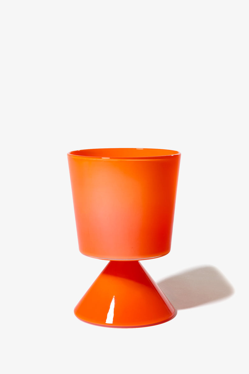 The Fiorelli Low Taper is a bright orange, cone-based cup or planter featuring a unique geometric design, casting a soft shadow on a white background.