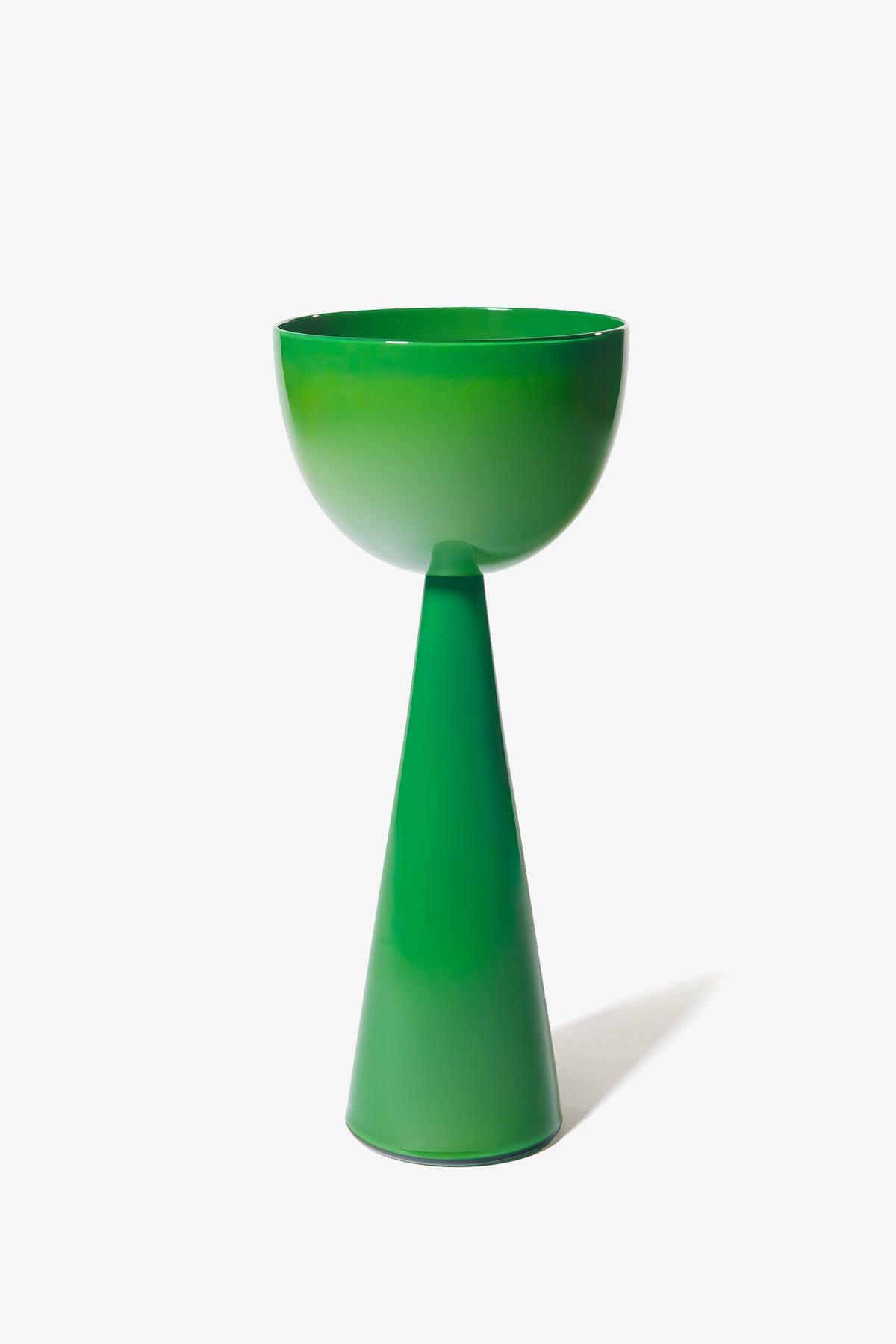 The Fiorelli Tall Bowl is a green, modern pedestal bowl with a glossy finish. It features smooth lines and a minimalist design, with the bowl resting atop a tall, conical base. The piece is presented against a plain white background.