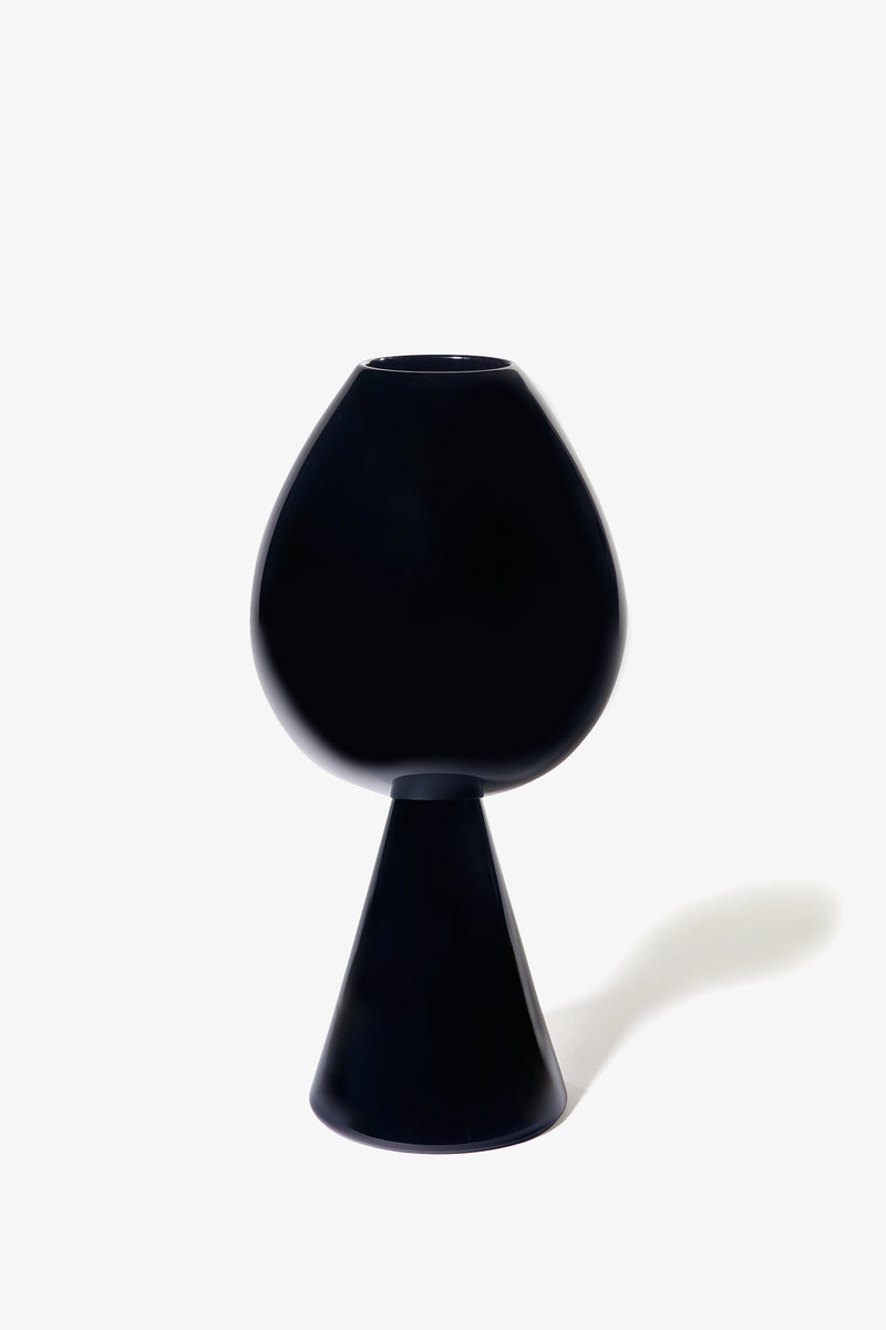 The Fiorelli Tulip, a modern black vase featuring a rounded top and conical base, is showcased on a white background with its shadow cast to the right.