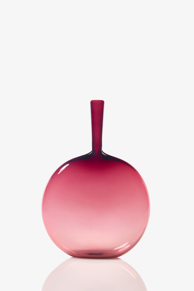 The Flask Angelic Bottle is a round glass vase with a narrow neck, showcasing a smooth gradient from deep pink at the top to light pink at the base, set against a white background.