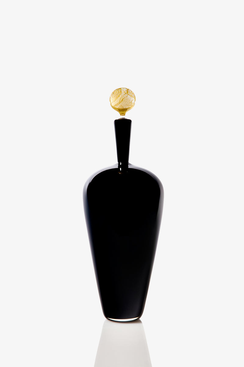 The High Shoulder Carmella Barware features a sleek, black bottle with a tall, elegant shape and a decorative gold-textured cap, shown upright against a plain white background.