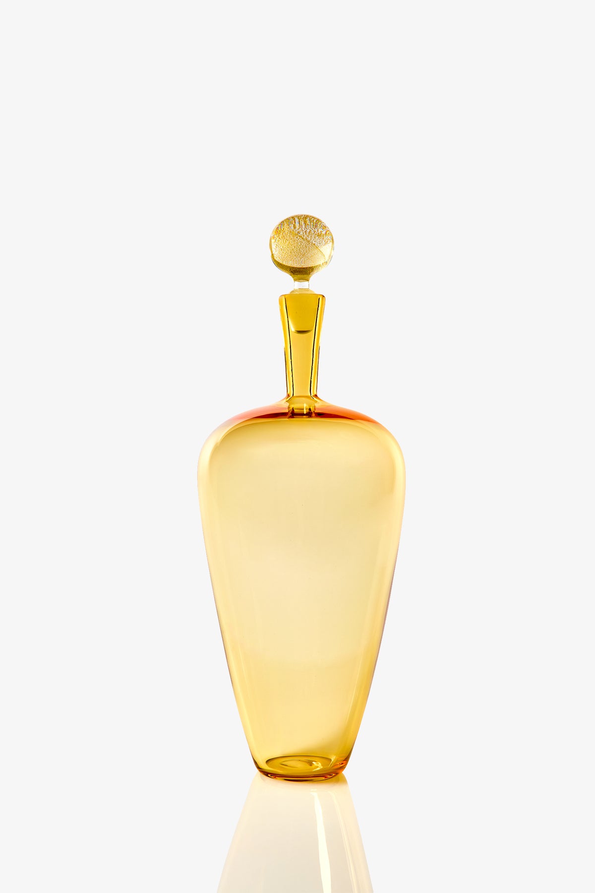 The High Shoulder Carmella Barware is a golden yellow glass bottle with a rounded stopper, smooth elegant shape, and reflective surface, showcased against a plain white background.