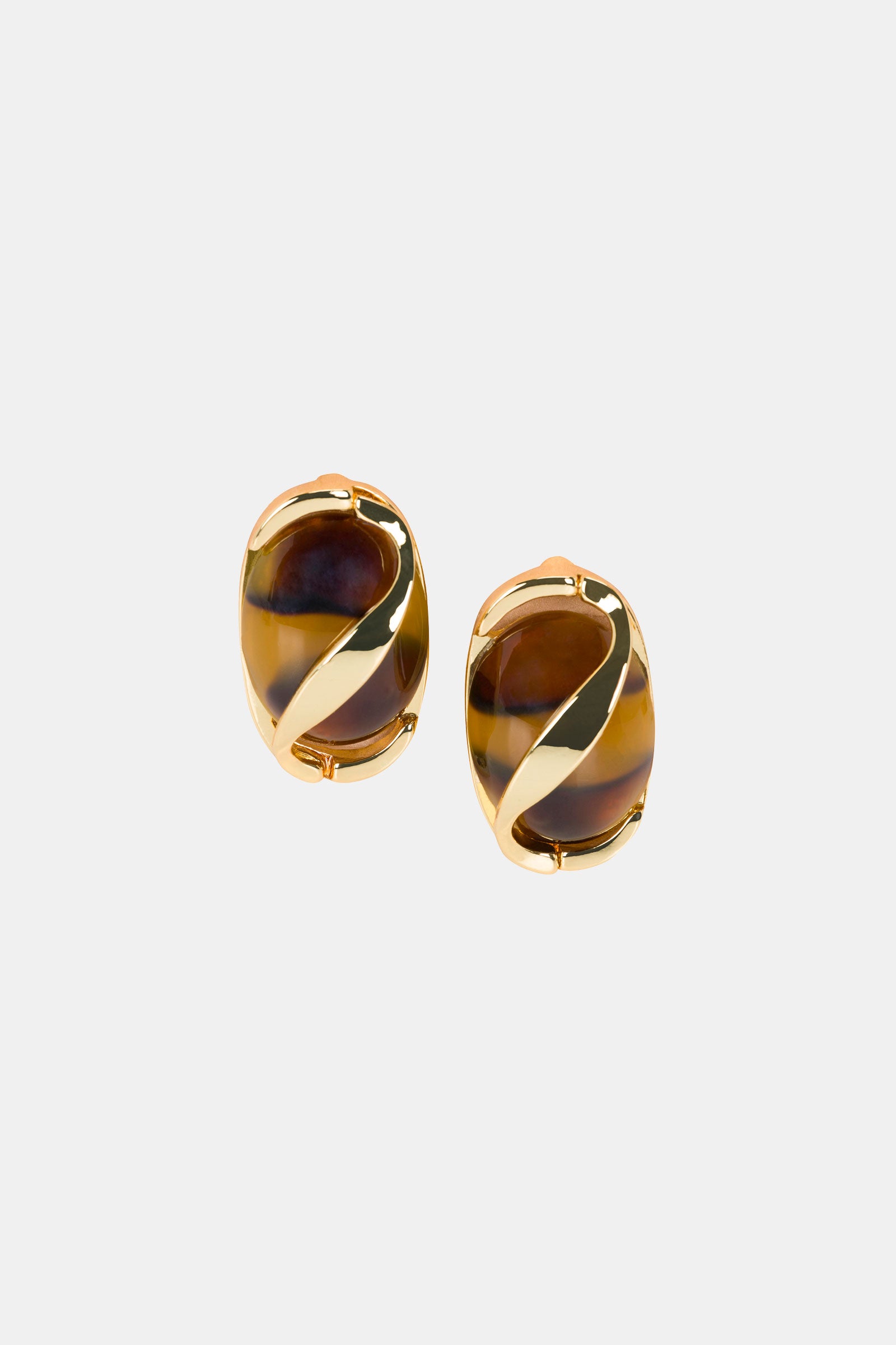 The Oval Tortoise Earring features clip-on, oval-shaped brown and gold tones with a swirling gold accent over a glossy, striped surface, shown on a plain light background.