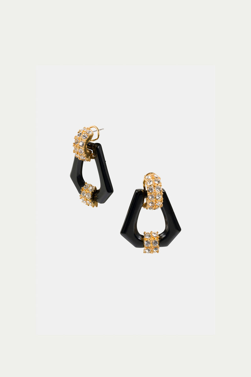The Hexagon Doorknocker Earrings are geometric black earrings with gold and crystal accents, featuring angular shapes and a modern, elegant design, shown against a plain white background.