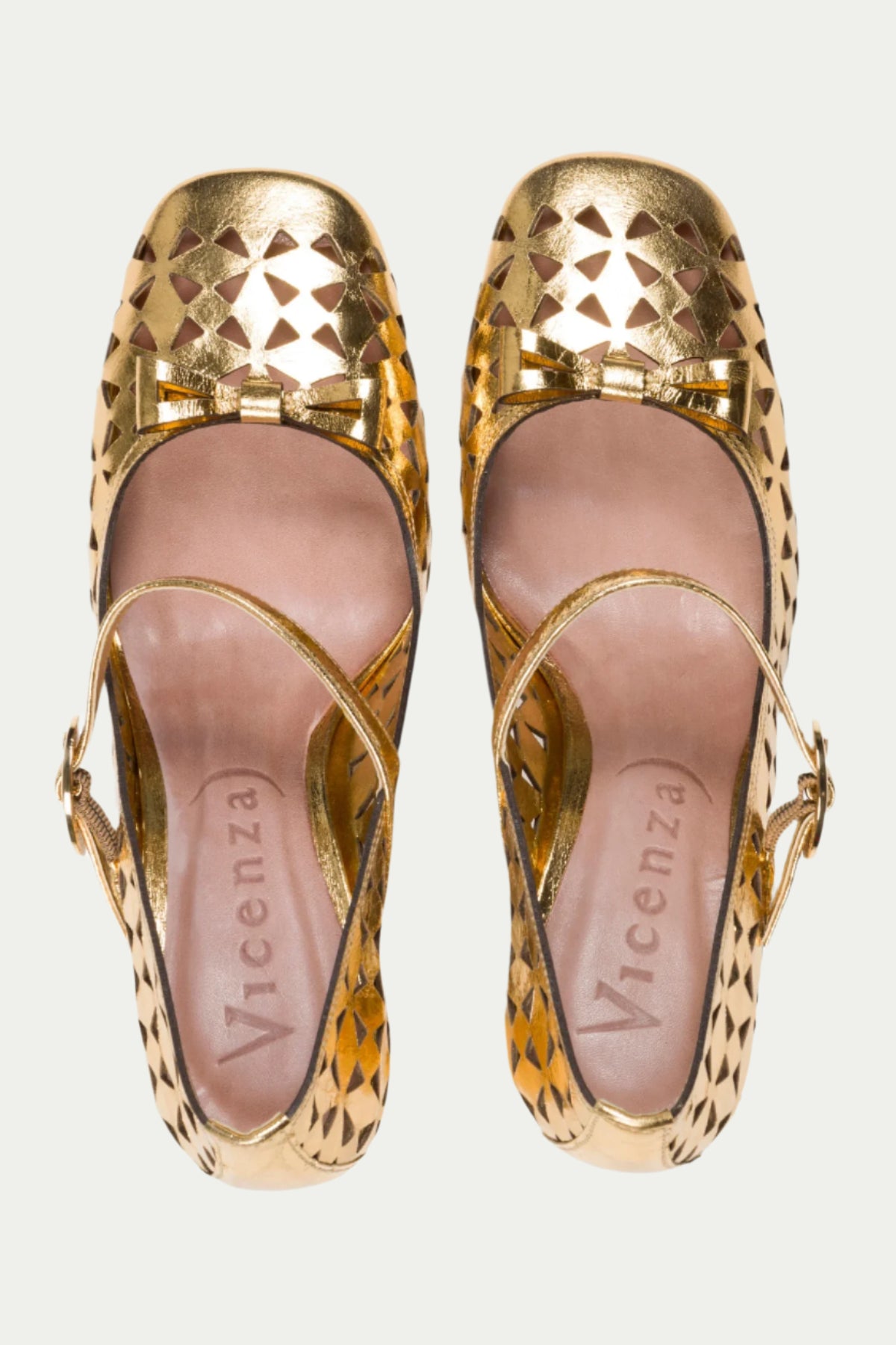 The Georgina Mary Jane Cutout Leather Heel in gold features geometric cut-outs, small toe bows, ankle straps, and pink insoles with the Vicenza logo.