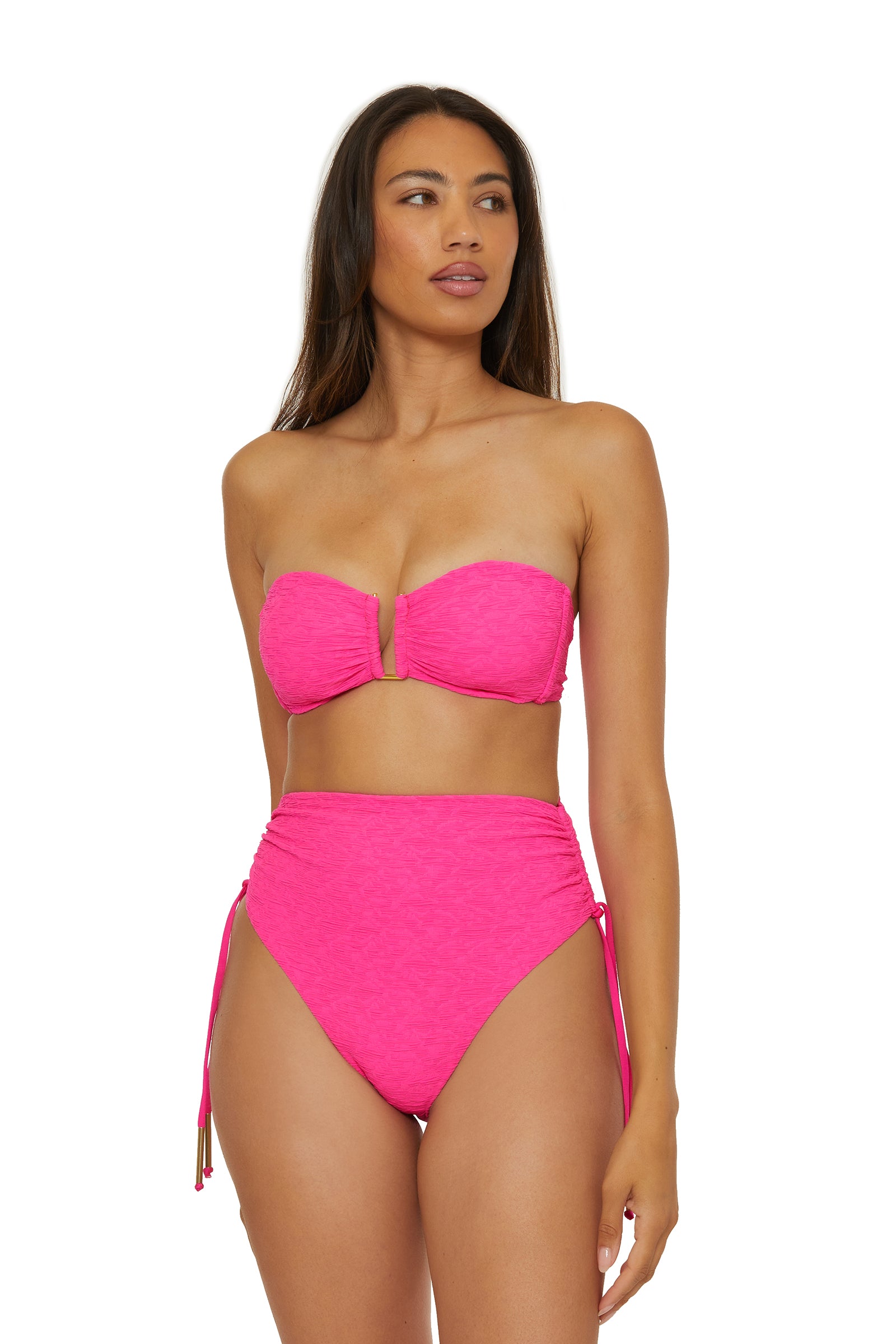 A woman models the Strapless Bandeau Swim Top - Indio in bright pink, paired with high-waisted side-tie bikini bottoms, standing against a plain white background and gazing slightly to the side.