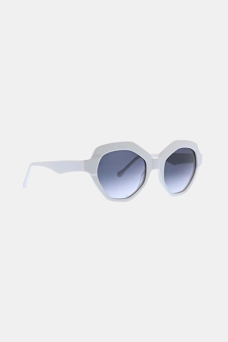 The Ipanema Sunglass features white octagonal frames with a thick design and gradient blue-tinted lenses, displayed angled to the right on a simple light background.
