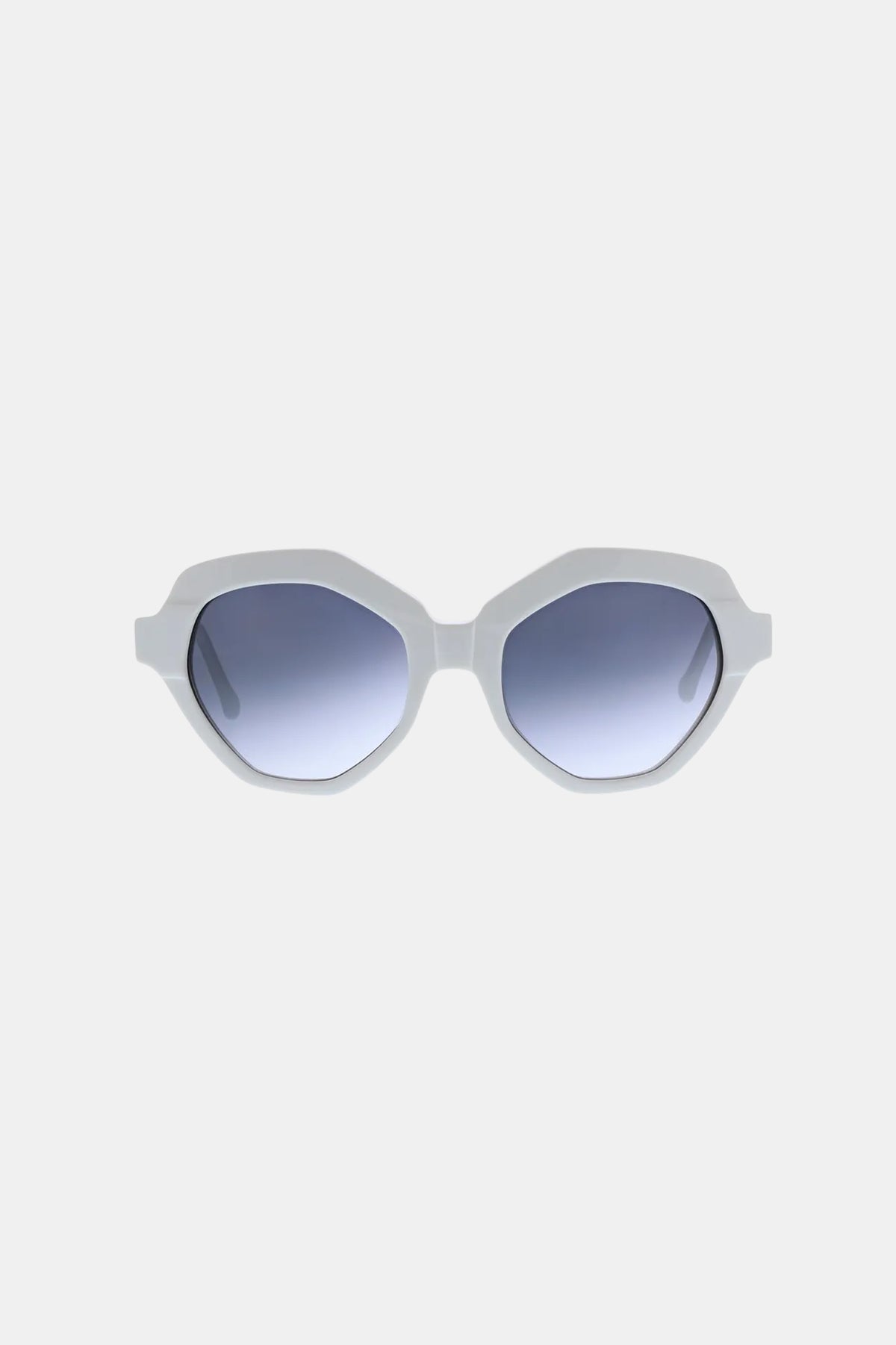 The Ipanema Sunglass features white, geometric-shaped thick frames and blue gradient lenses, showcased against a plain light gray background.