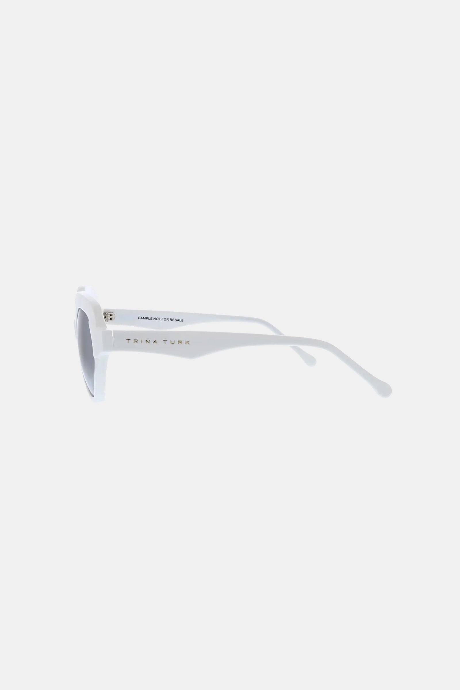 Side view of Ipanema Sunglass in white with rectangular lenses and slightly curved arms, featuring "TRINA TURK" on the temple.