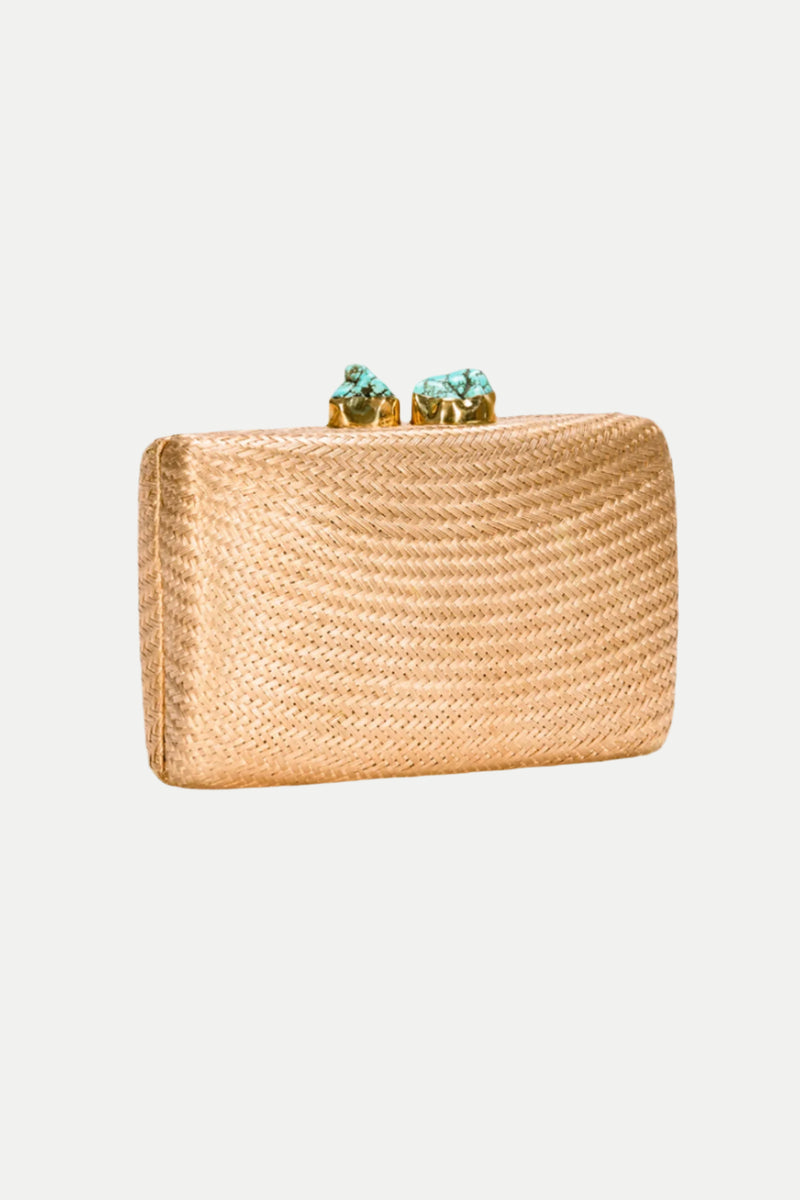 The Jen Gold Straw Clutch features a rectangular woven gold design and a textured surface, with a top clasp adorned by two turquoise stones, displayed against a plain white background.