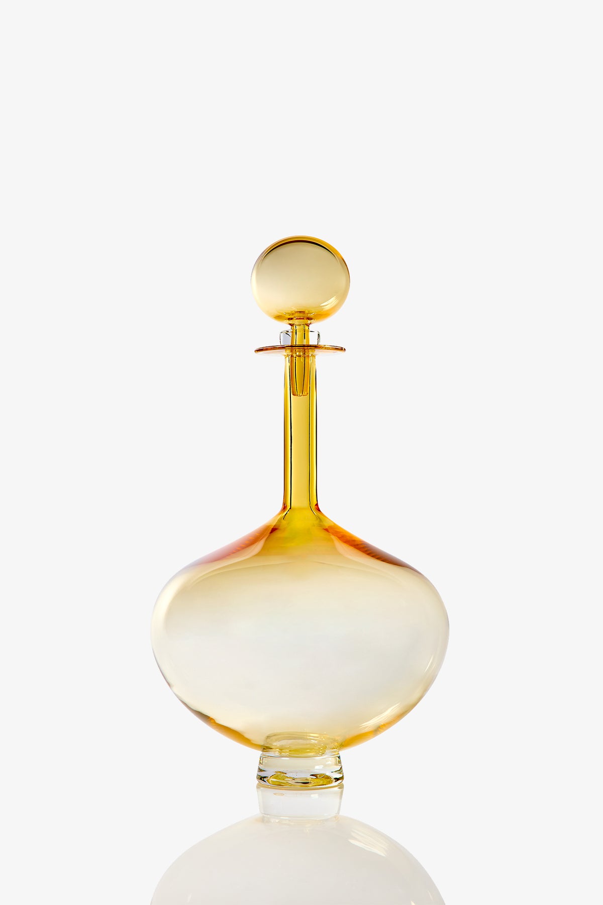 A Large Genie Bottle Decanter, crafted from clear glass with a round stopper and tinted in shades of yellow and orange, is displayed against a white background.