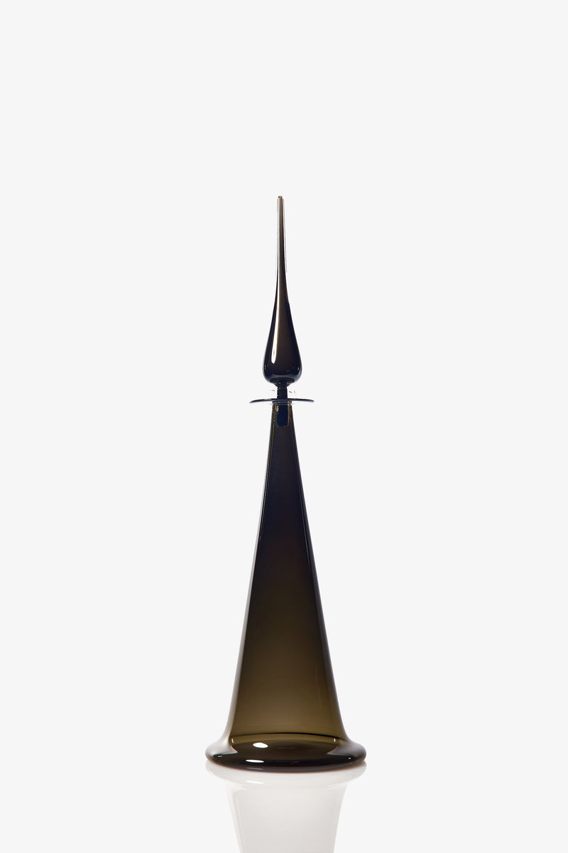 A Large Fluted Cone Decanter made of dark glass, featuring a wide base that tapers elegantly to a narrow, pointed top, is displayed against a plain white background.