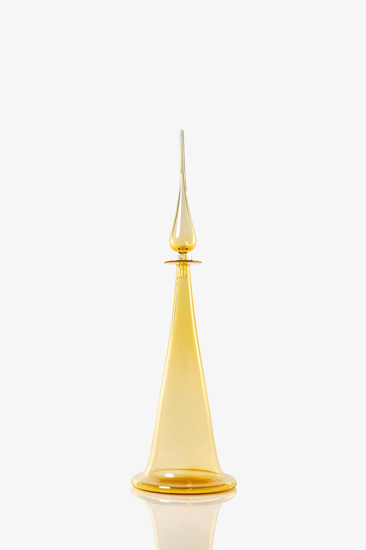 A Large Fluted Cone Decanter, featuring an elegant, tall amber-colored glass body with a pointed stopper and wide base, is displayed against a plain white background.