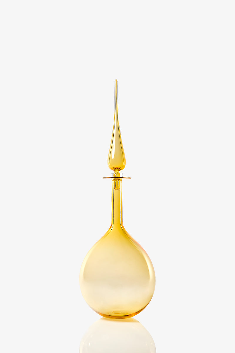 A translucent, golden-yellow Large Tear Drop Decanter with a rounded base and a tall, pointed stopper, set against a plain white background.