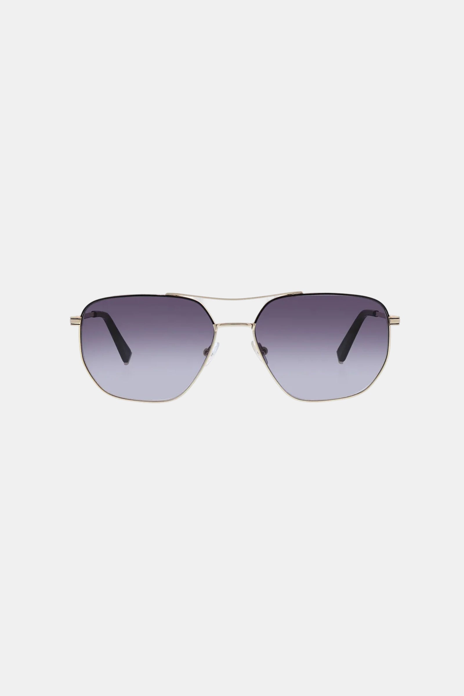 The Le Chance Sunglass features thin gold metal aviator frames and dark gradient lenses, displayed against a plain light gray background.