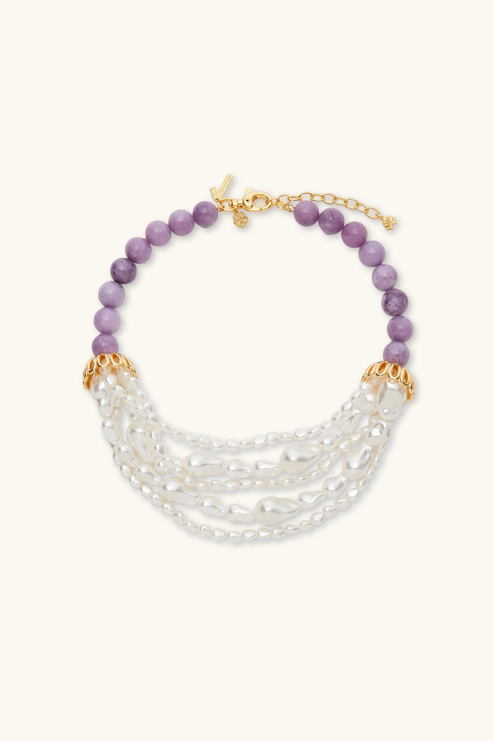 The Lele Sadoughi x Trina Turk Parapluie Strand Necklace features lavender beads, gold-tone accents, and multiple strands of white pearls with an adjustable gold clasp.