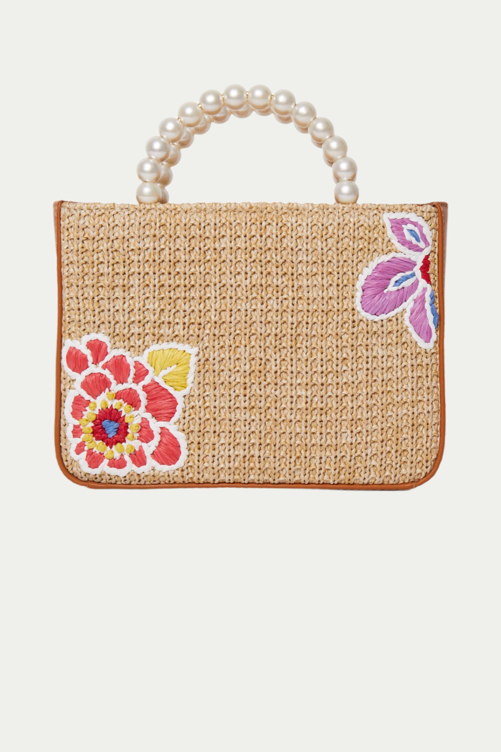 The Lele Sadoughi x Trina Turk Maya Floral Mini Tote is a rectangular woven straw bag featuring a pearl beaded handle, brown trim, and colorful embroidered floral designs on the front.