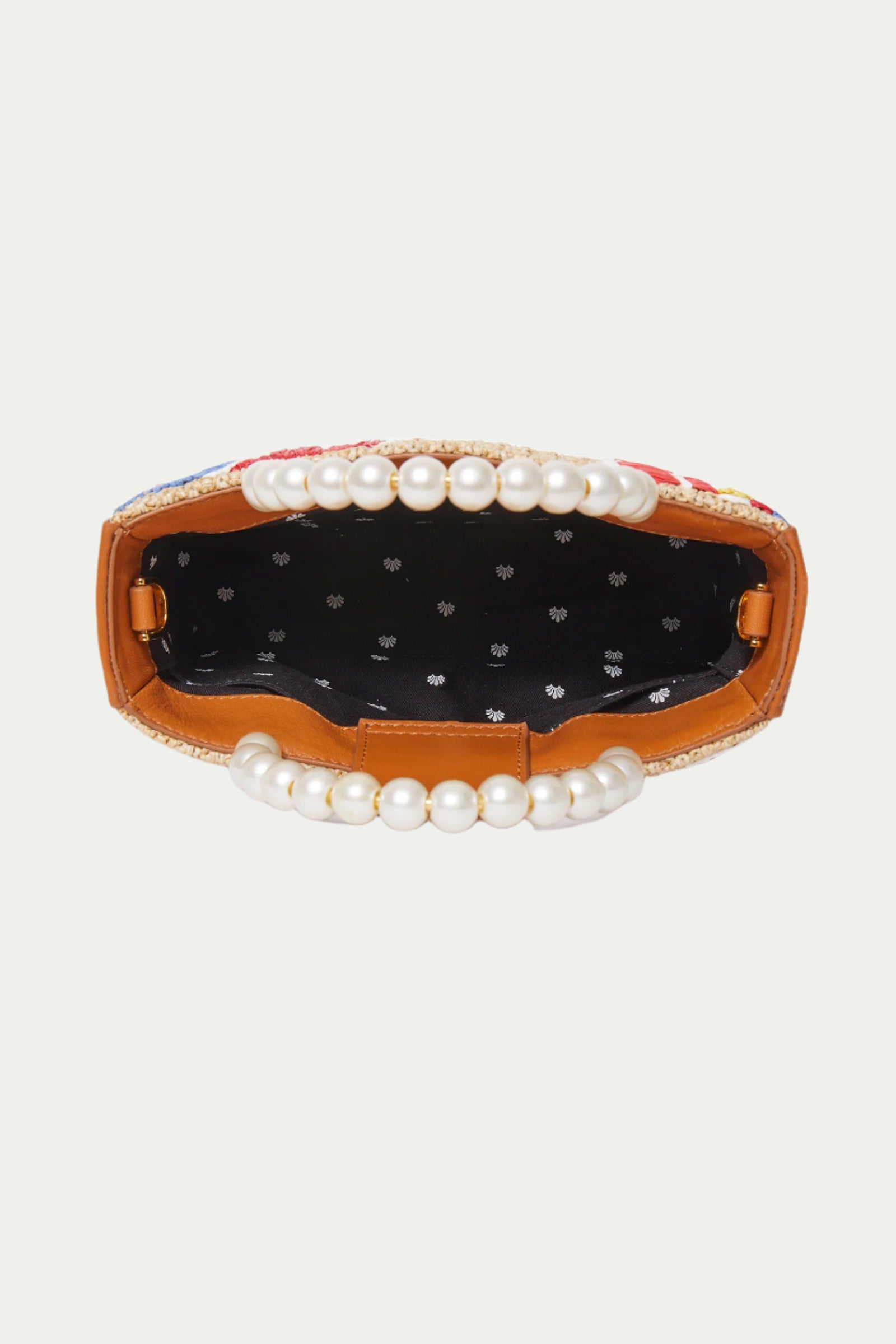 Top view of the Lele Sadoughi x Trina Turk Maya Floral Mini Tote, featuring a pearl beaded handle, brown trim, and a black fabric interior with small white motifs.