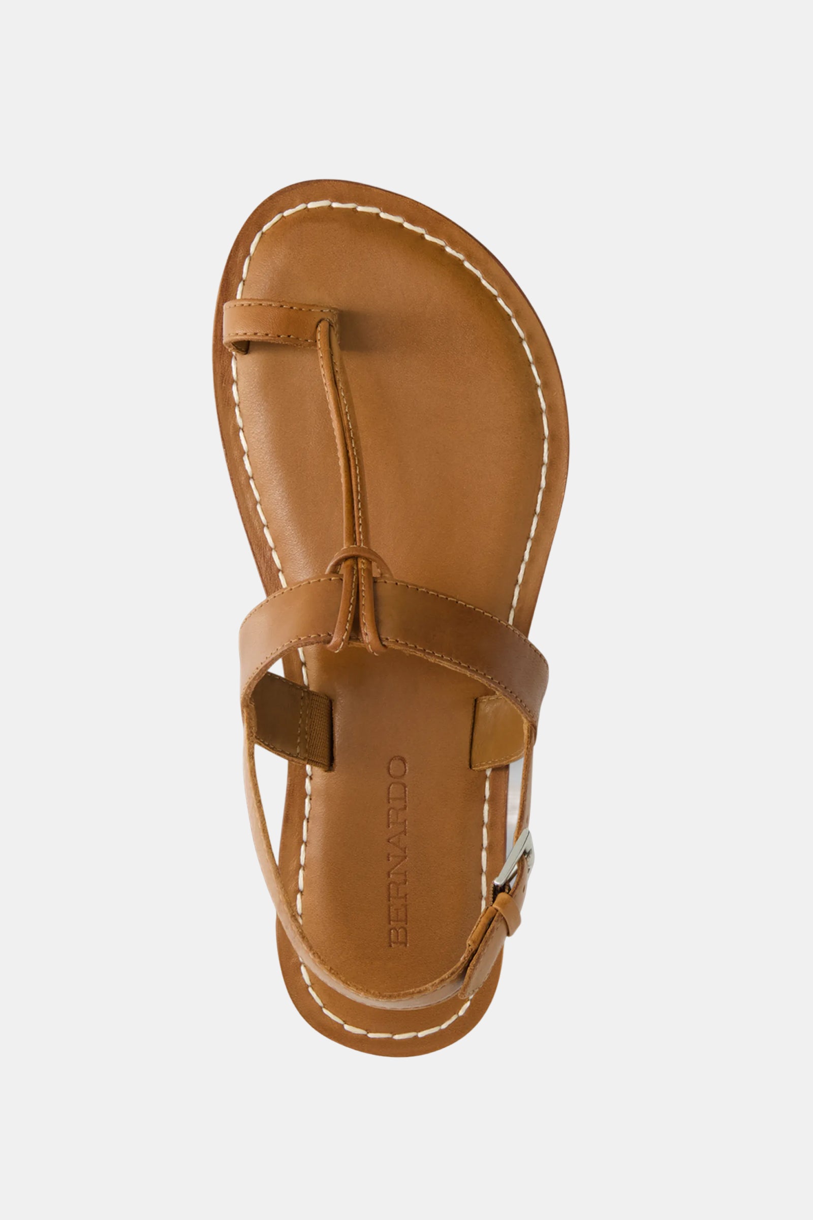 The Bernardo Maverick 2 Sandal is a tan leather, open-toe, T-strap sandal with white stitching, an ankle strap and buckle, and "BERNARDO" stamped on the insole.