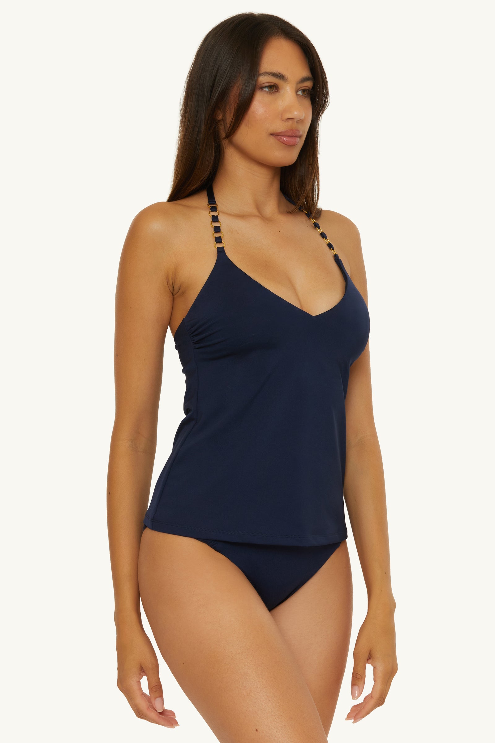 A woman wears the Ring Tankini Swim Top - Monaco, featuring decorative strap details and matching bikini bottoms, against a plain light background.