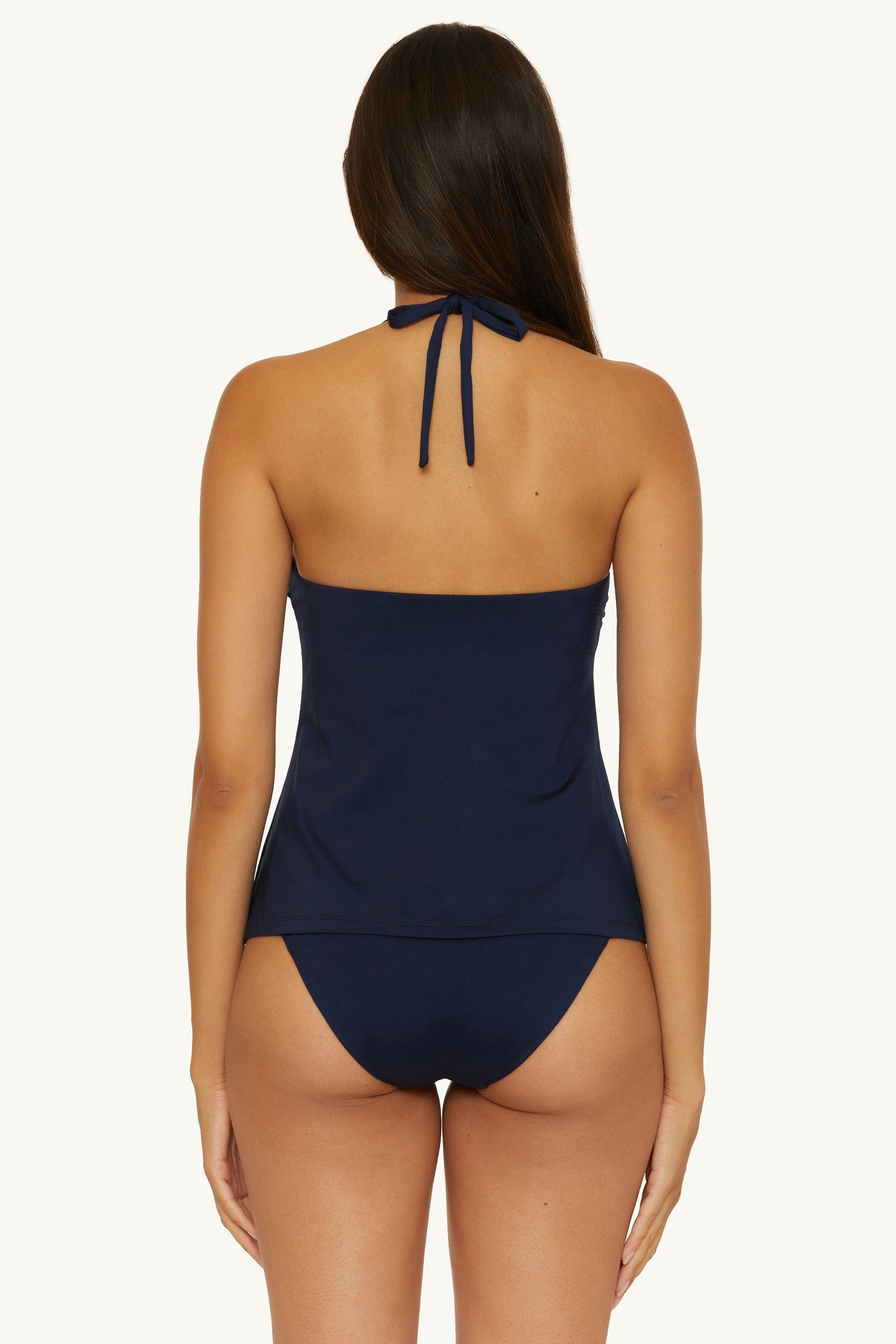 A woman is shown from the back wearing the Ring Tankini Swim Top - Monaco in navy blue with matching bikini bottoms against a plain light background.