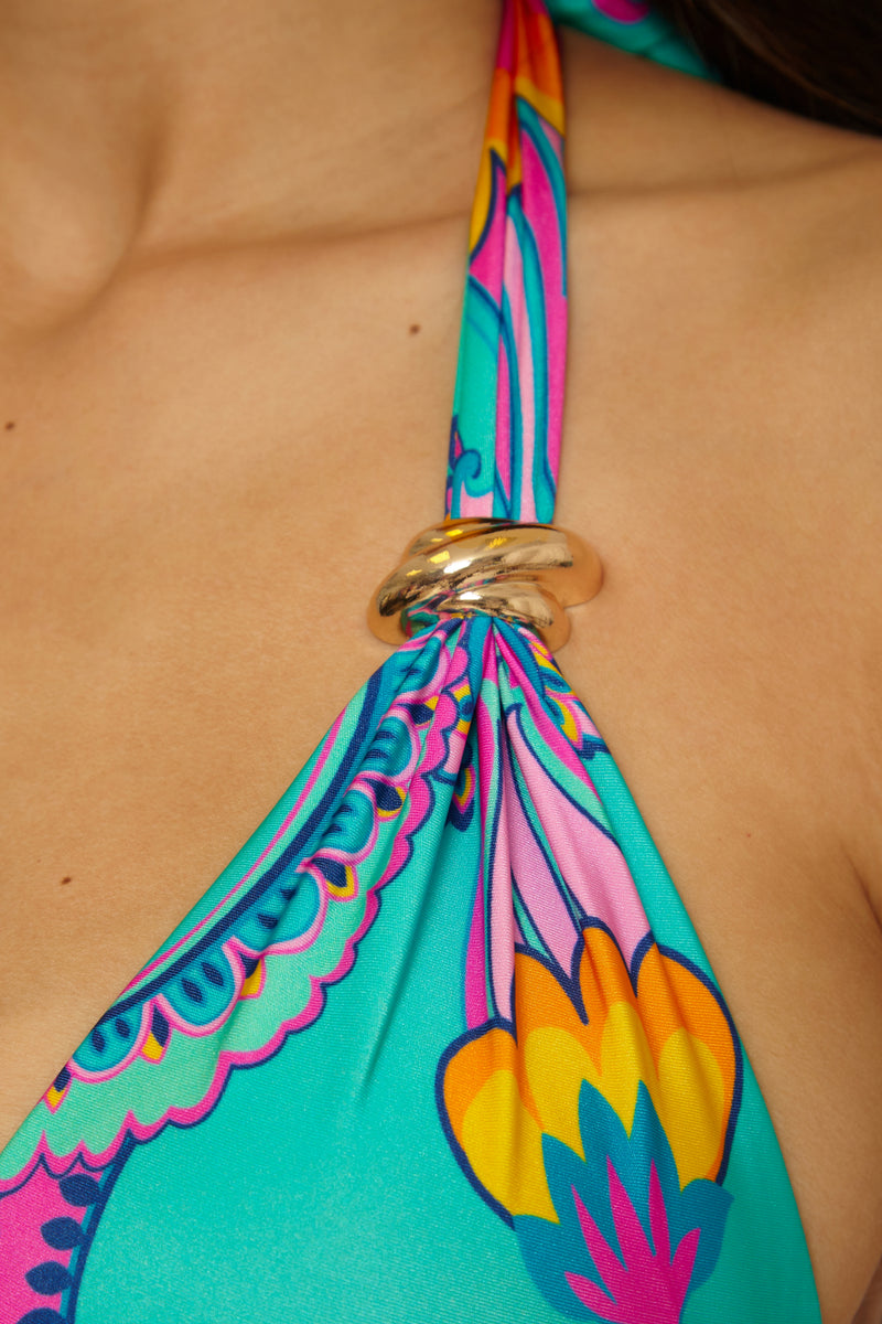 Close-up of the Mykonos Banded Halter Top featuring a gold ring detail at the strap and vibrant teal, pink, orange, and purple patterns against light skin.