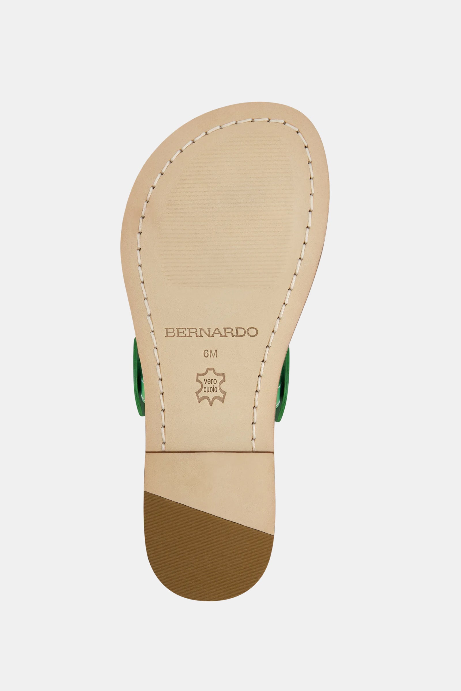 The underside of the Bernardo New Moon Sandal in beige features visible stitching, a BERNARDO label, star icon with VERO CUOIO, size 6M marking, and a darker brown heel.
